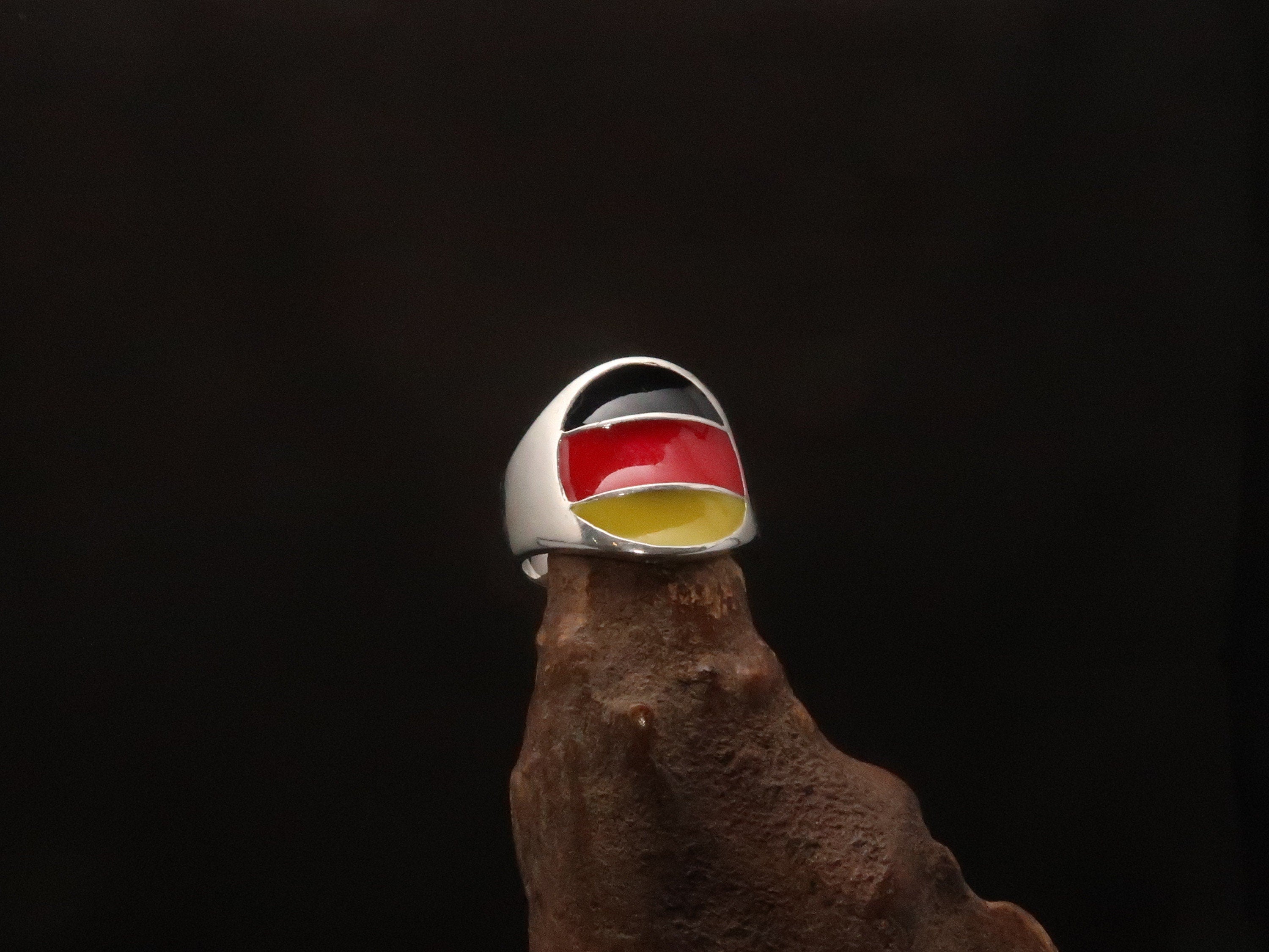A stylish German Flag Ring made of polished sterling silver, featuring the colors of the German flag in a round pinky ring design.