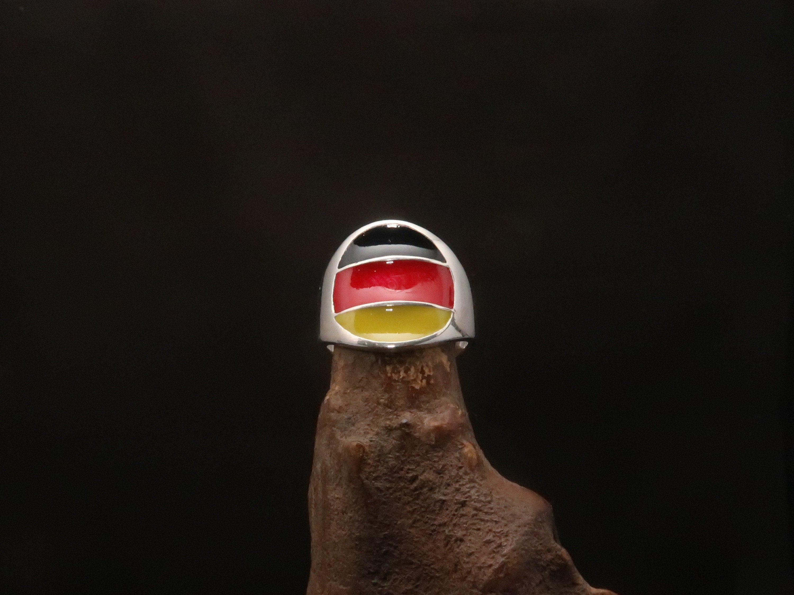 A stylish German Flag Ring made of polished sterling silver, featuring the colors of the German flag in a round pinky ring design.