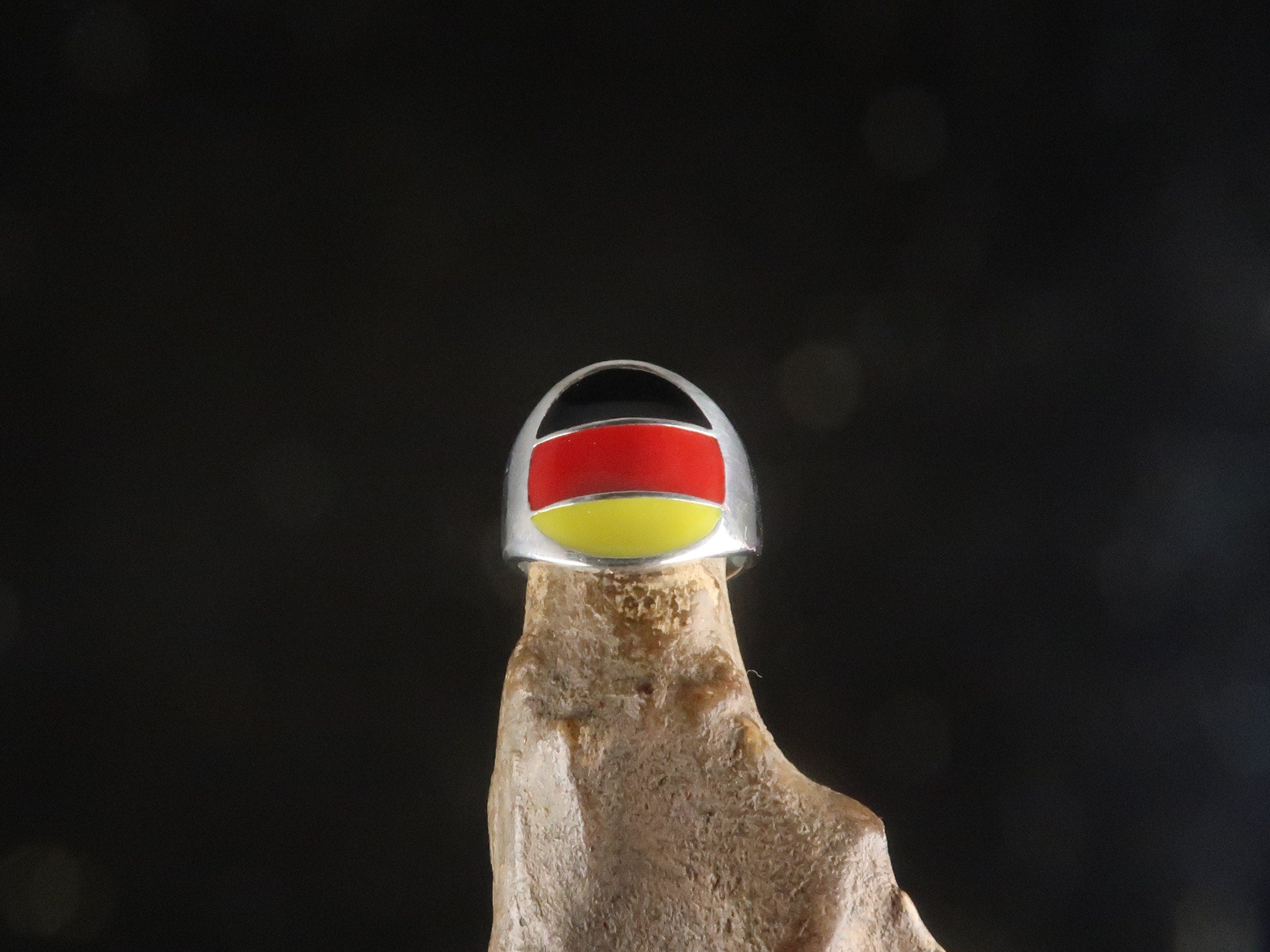 A stylish German Flag Ring made of polished sterling silver, featuring the colors of the German flag in a round pinky ring design.