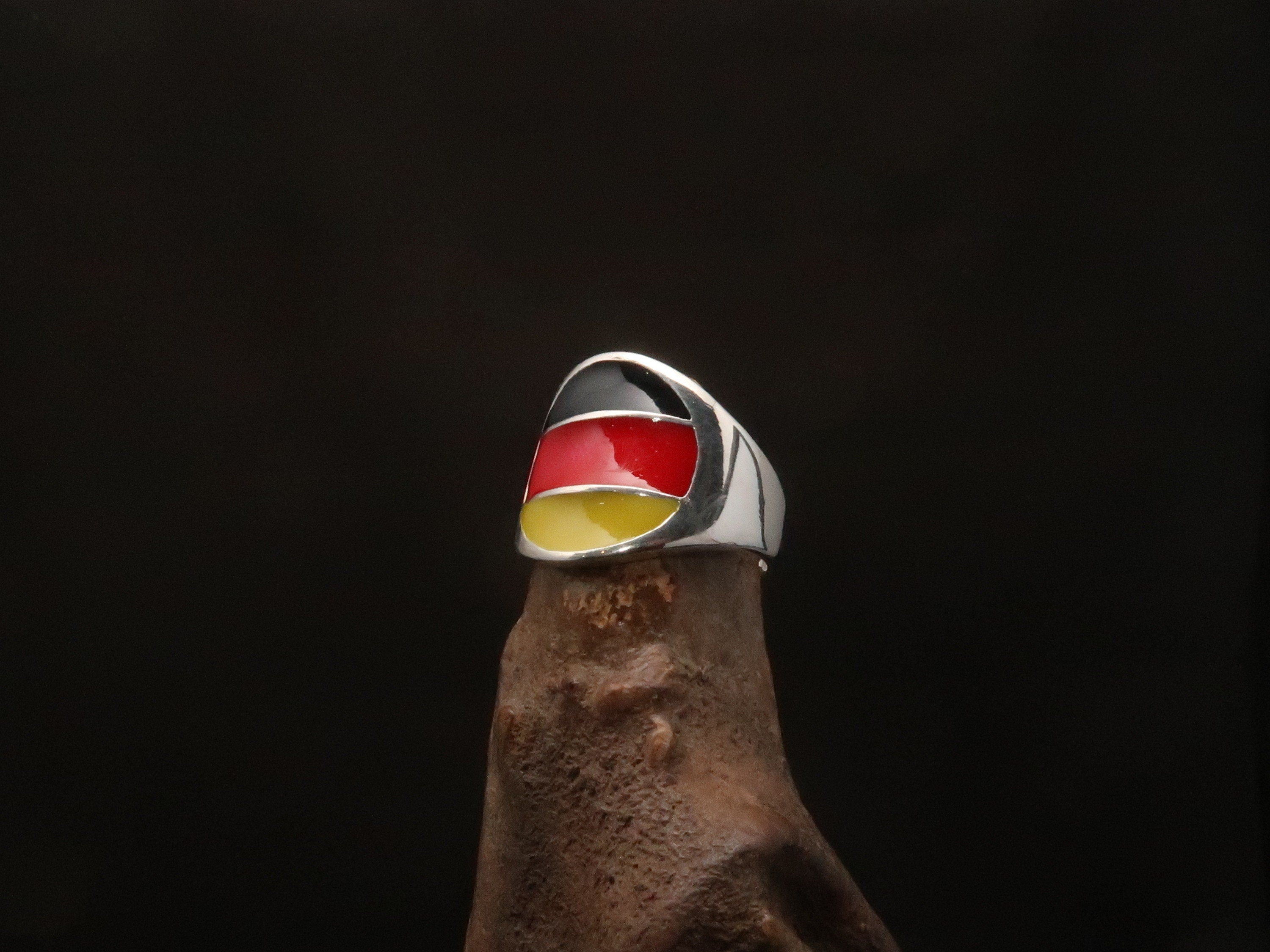 A stylish German Flag Ring made of polished sterling silver, featuring the colors of the German flag in a round pinky ring design.