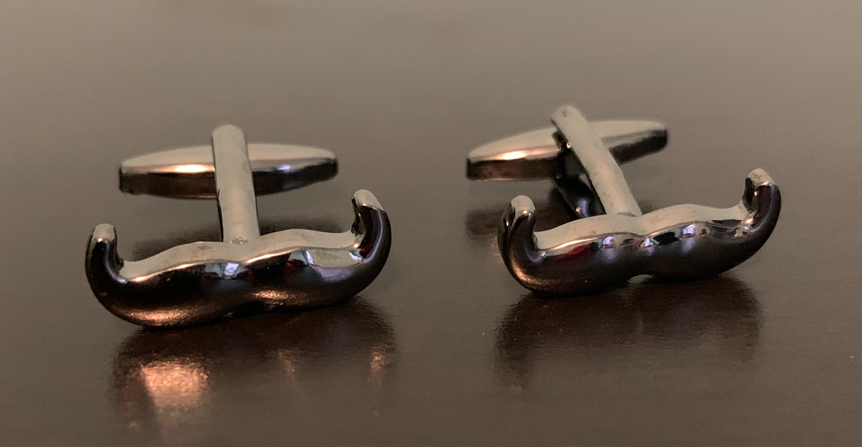 Dark pewter cufflinks featuring a unique handlebar moustache design, perfect for gentlemen.
