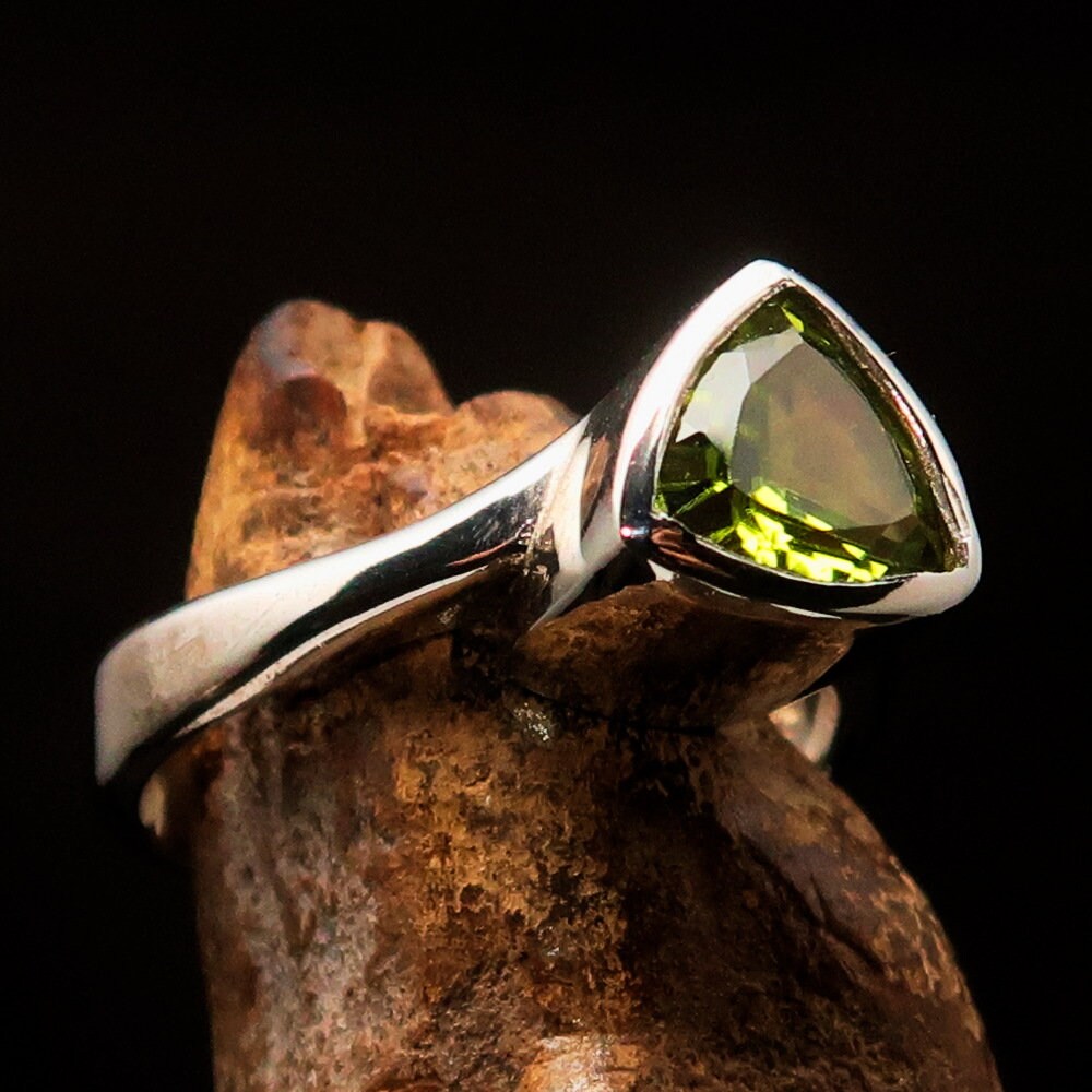 A beautiful green Peridot ring in sterling silver with a trillion cut gemstone, showcasing its mirror-polished finish.