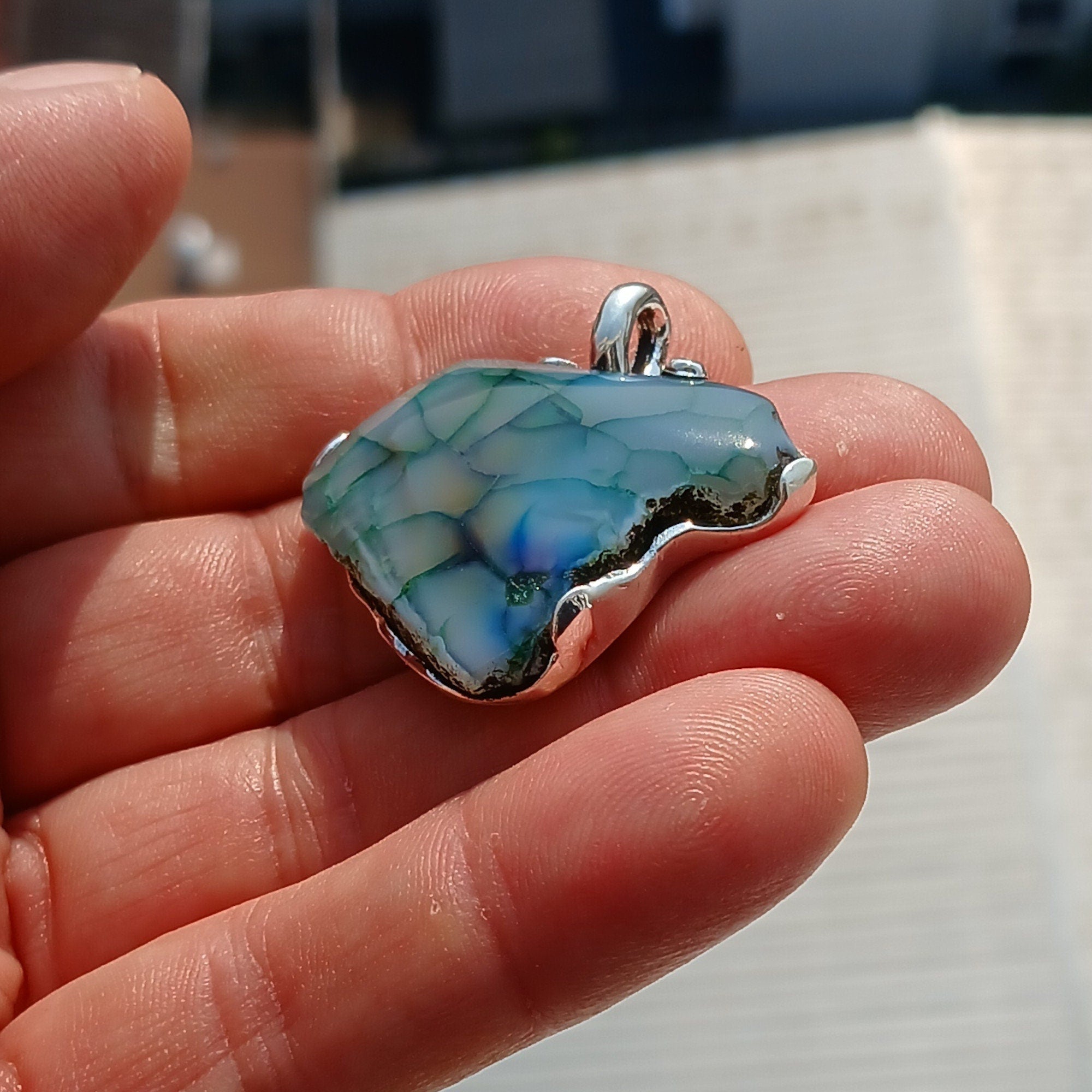 A beautiful Greenish Agate Amulet Sterling Silver Pendant featuring a vibrant green Agate stone set in intricate sterling silver artwork.