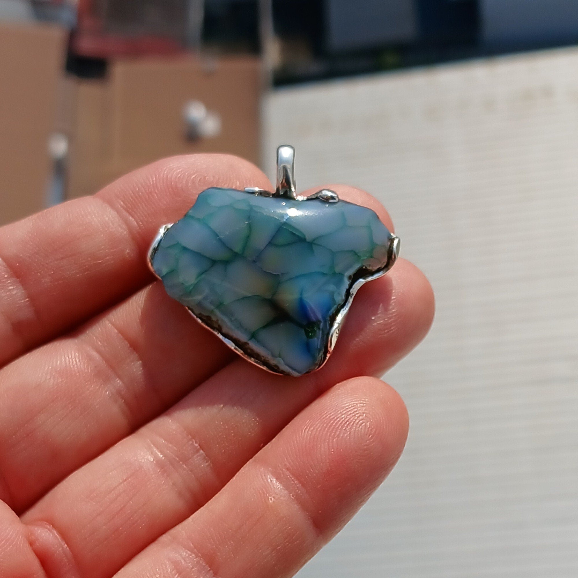 A beautiful Greenish Agate Amulet Sterling Silver Pendant featuring a vibrant green Agate stone set in intricate sterling silver artwork.