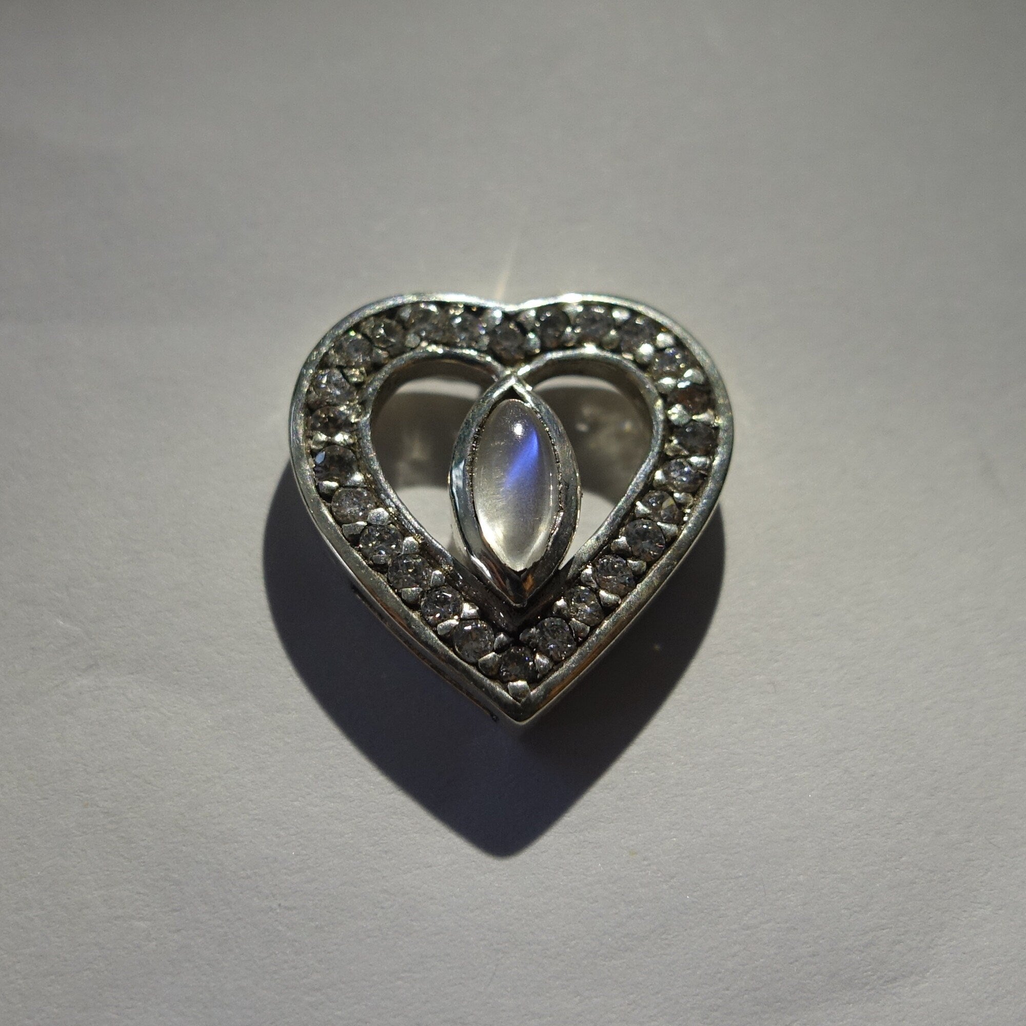 Sterling silver heart pendant featuring a Ceylon moonstone, elegantly designed with a polished finish.