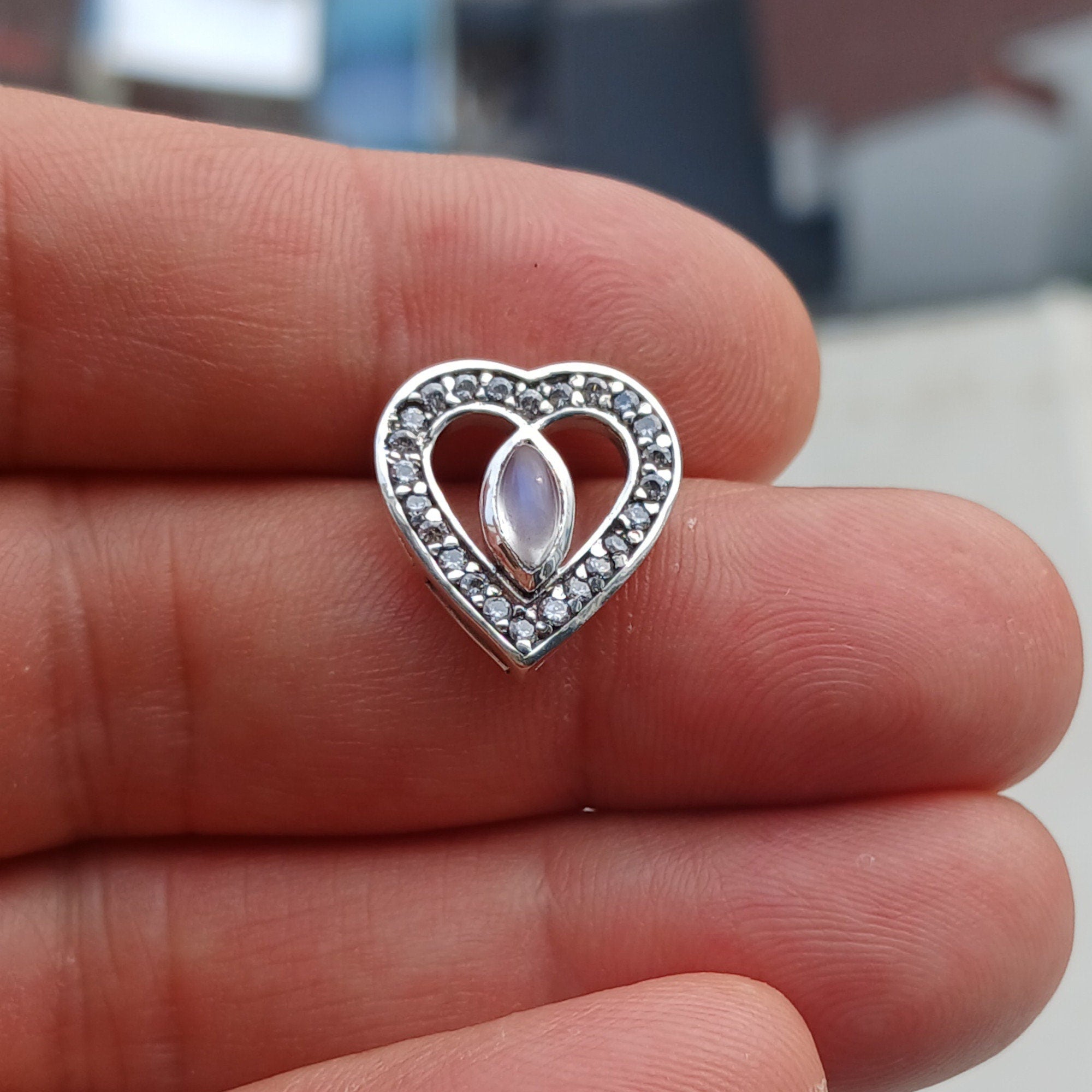 Sterling silver heart pendant featuring a Ceylon moonstone, elegantly designed with a shimmering finish.