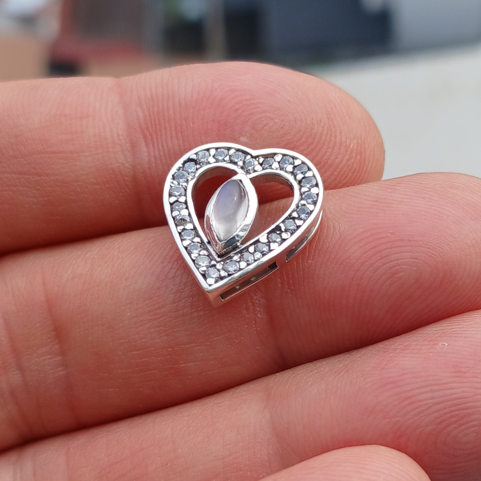 Sterling silver heart pendant featuring a Ceylon moonstone, elegantly designed with a shimmering finish.