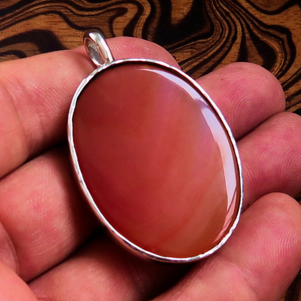 Heart Silver Pendant made of sterling silver featuring a vibrant orange Agate cabochon at the center, showcasing intricate details.