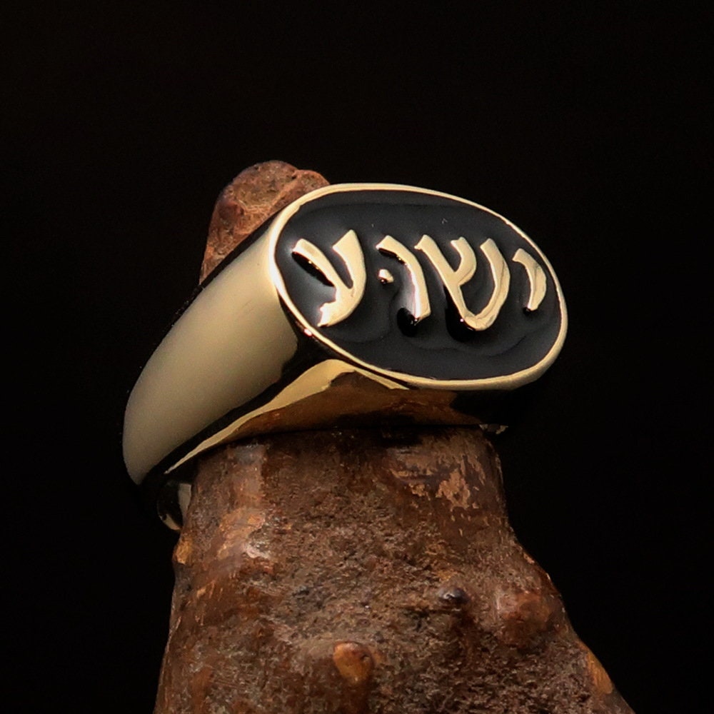 A polished brass oval-shaped pinky ring featuring the Hebrew word for Jesus, elegantly engraved and hallmarked 925.