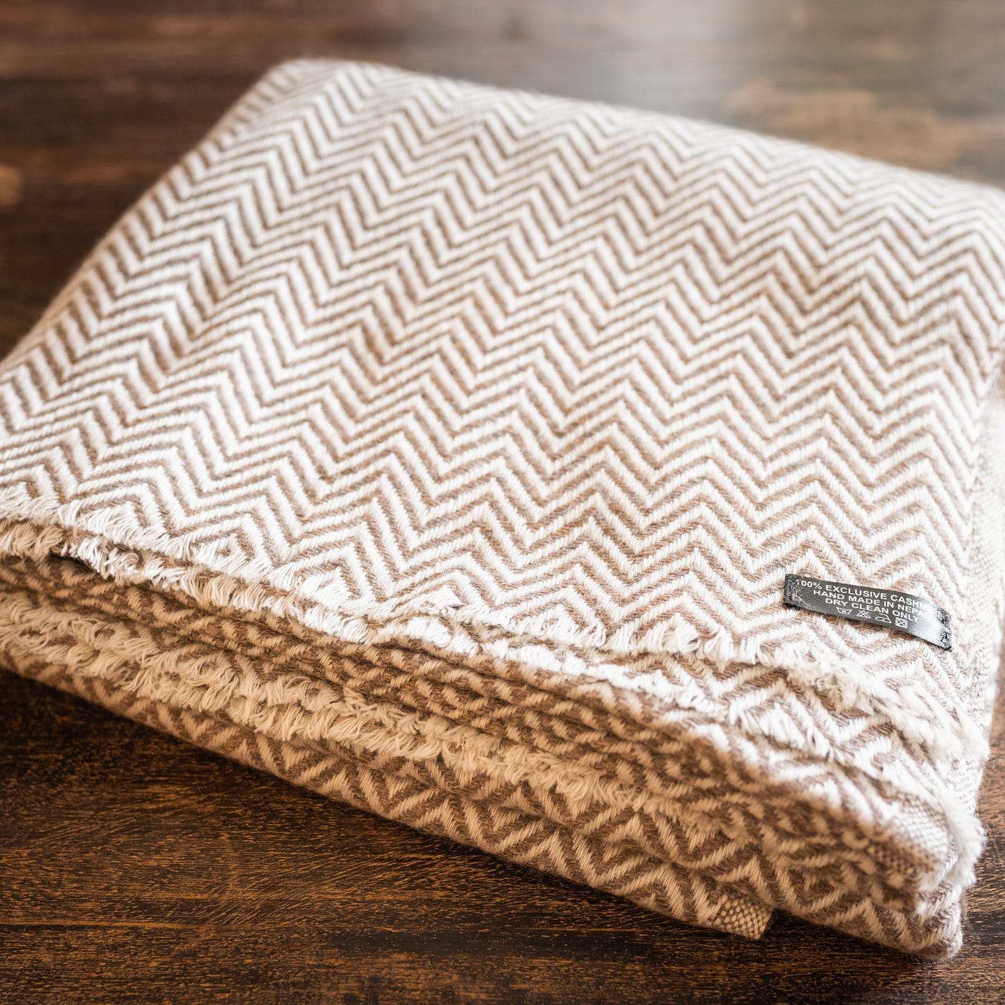 Graubraune Kaschmirdecke mit großem Fischgrätenmuster, handgewebt in Nepal, ideal für stilvolle Gemütlichkeit.