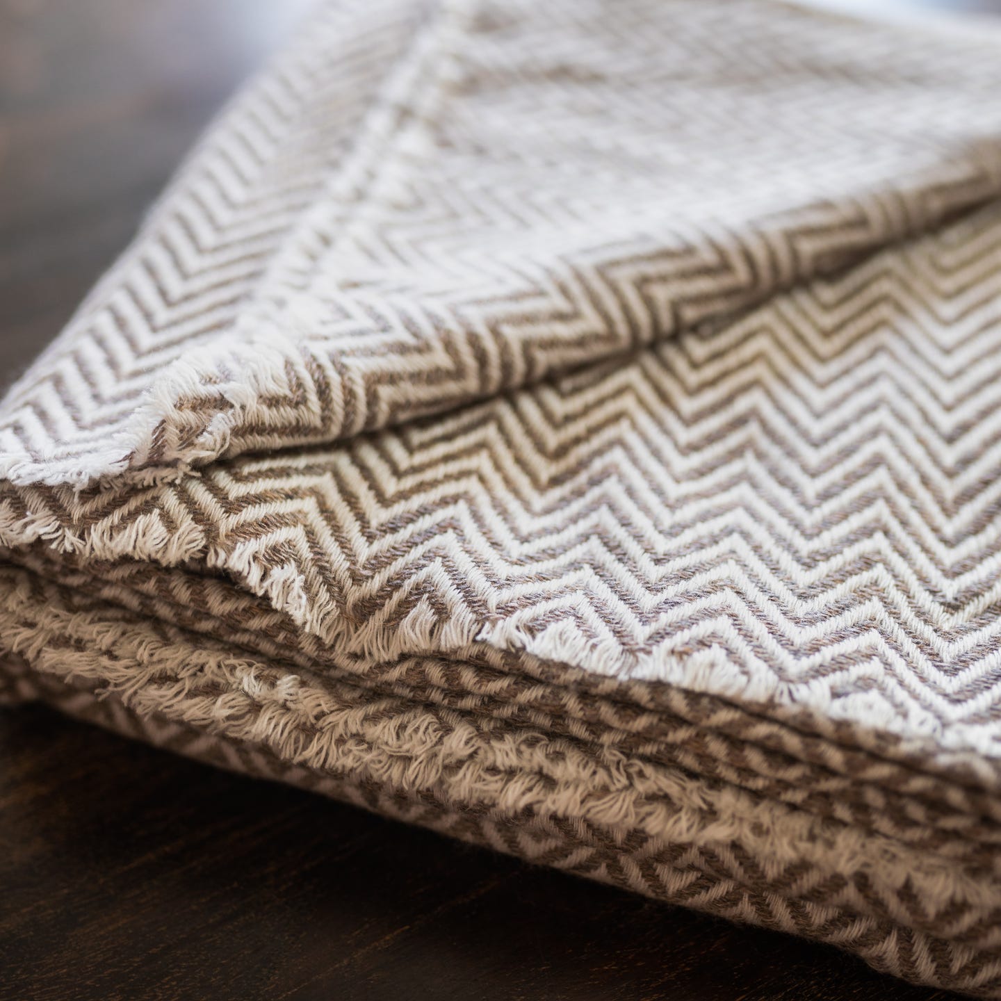 Graubraune Kaschmirdecke mit großem Fischgrätenmuster, handgewebt in Nepal, ideal für stilvolle Gemütlichkeit.