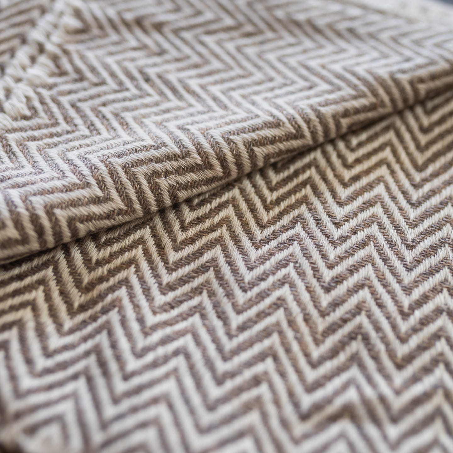 Graubraune Kaschmirdecke mit großem Fischgrätenmuster, handgewebt in Nepal, ideal für stilvolle Gemütlichkeit.