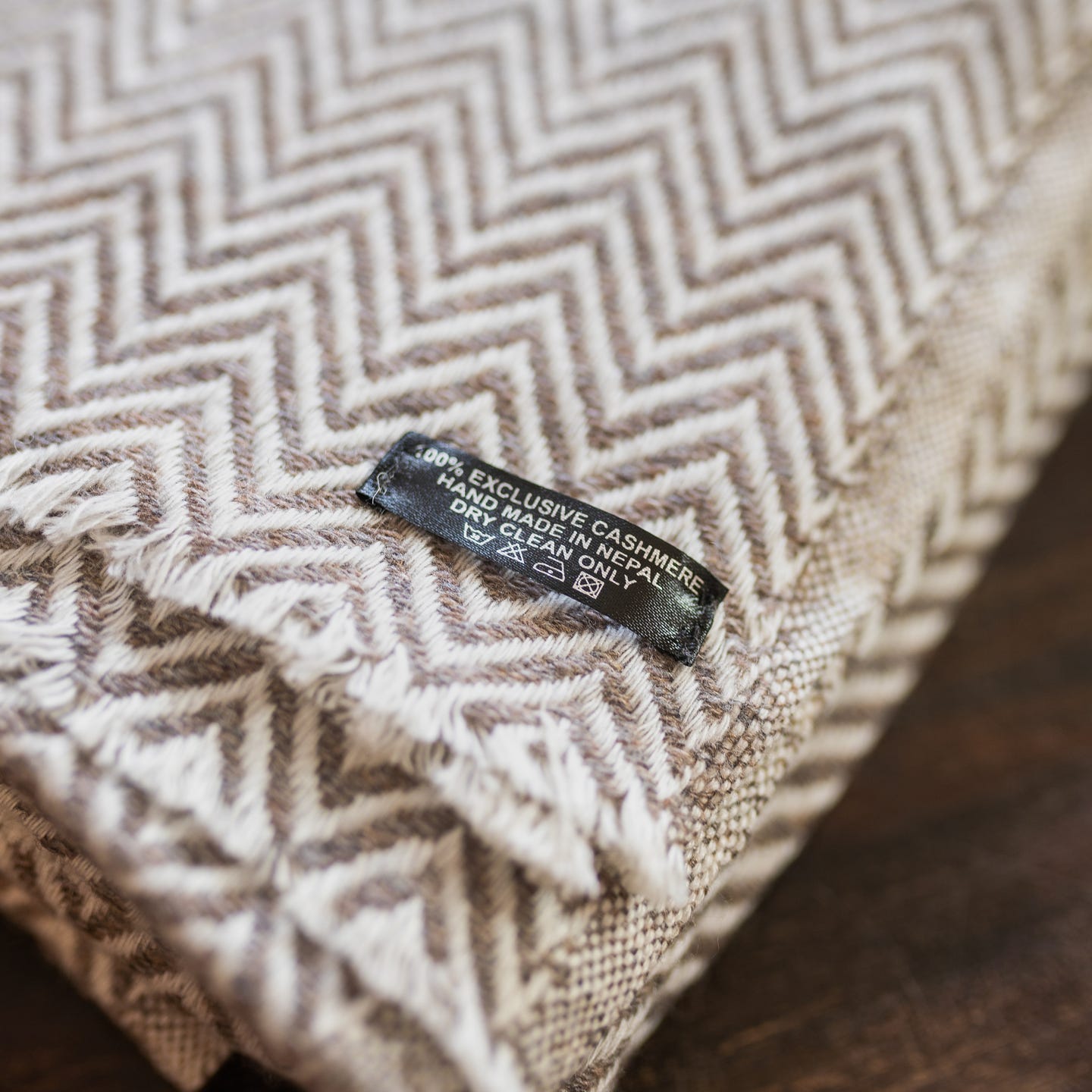 Graubraune Kaschmirdecke mit großem Fischgrätenmuster, handgewebt in Nepal, ideal für stilvolle Gemütlichkeit.