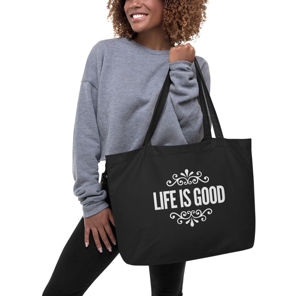 Large black tote bag made of durable cotton with inspirational print, featuring dual straps and spacious interior.