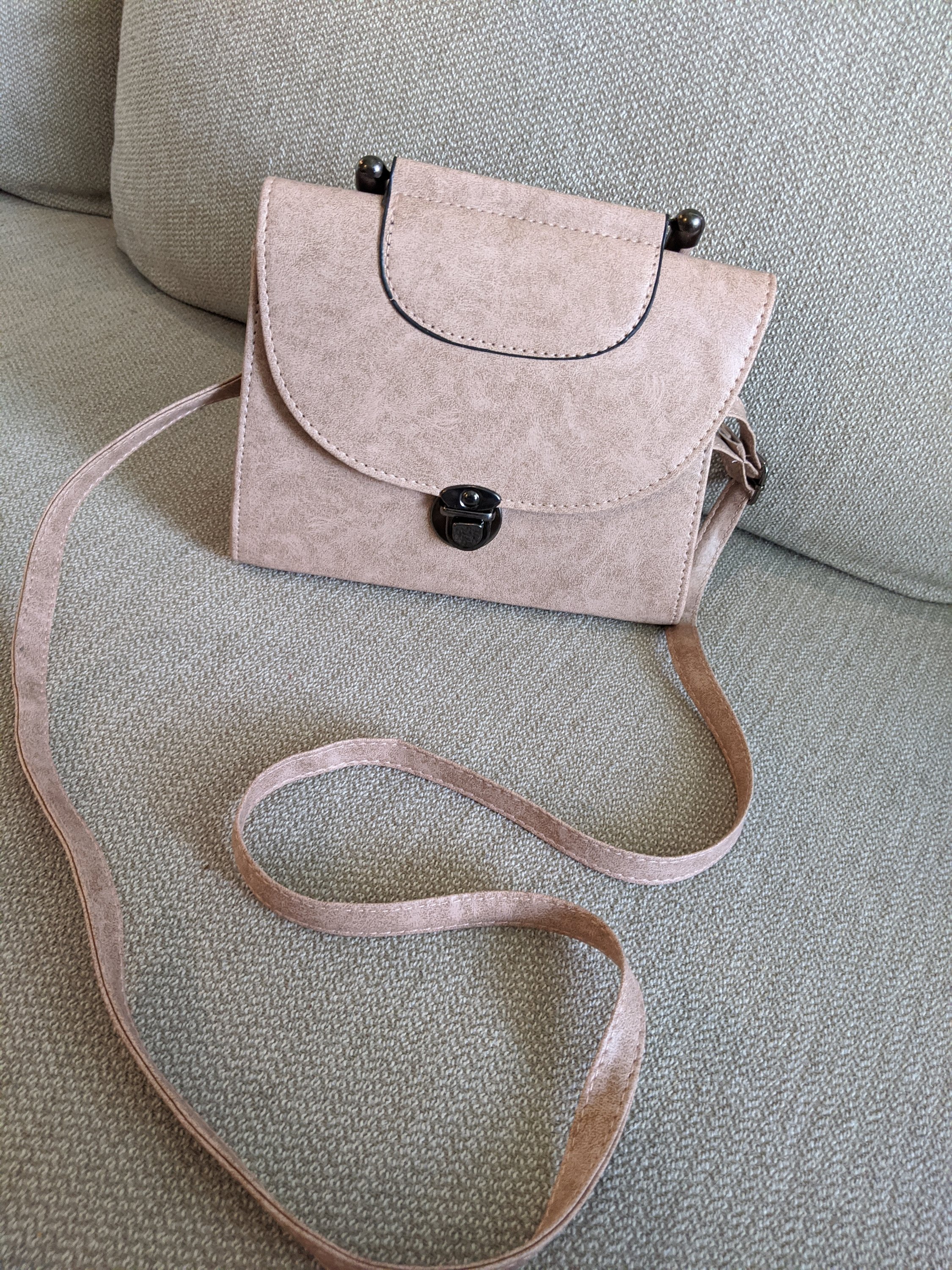 Light mauve faux leather marbled crossbody bag with adjustable strap, showcasing its soft texture and stylish design.