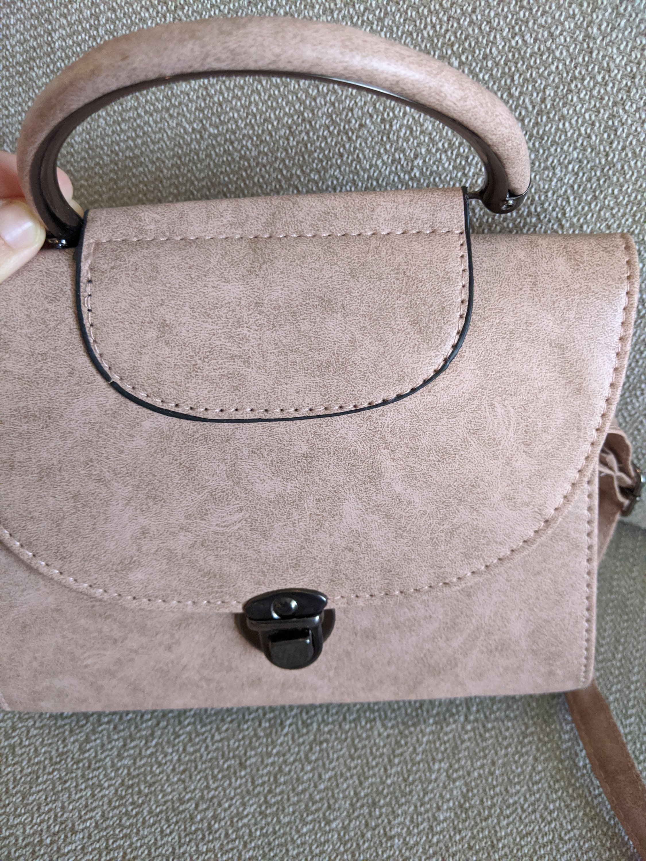 Light mauve faux leather marbled crossbody bag with adjustable strap, showcasing its soft texture and stylish design.