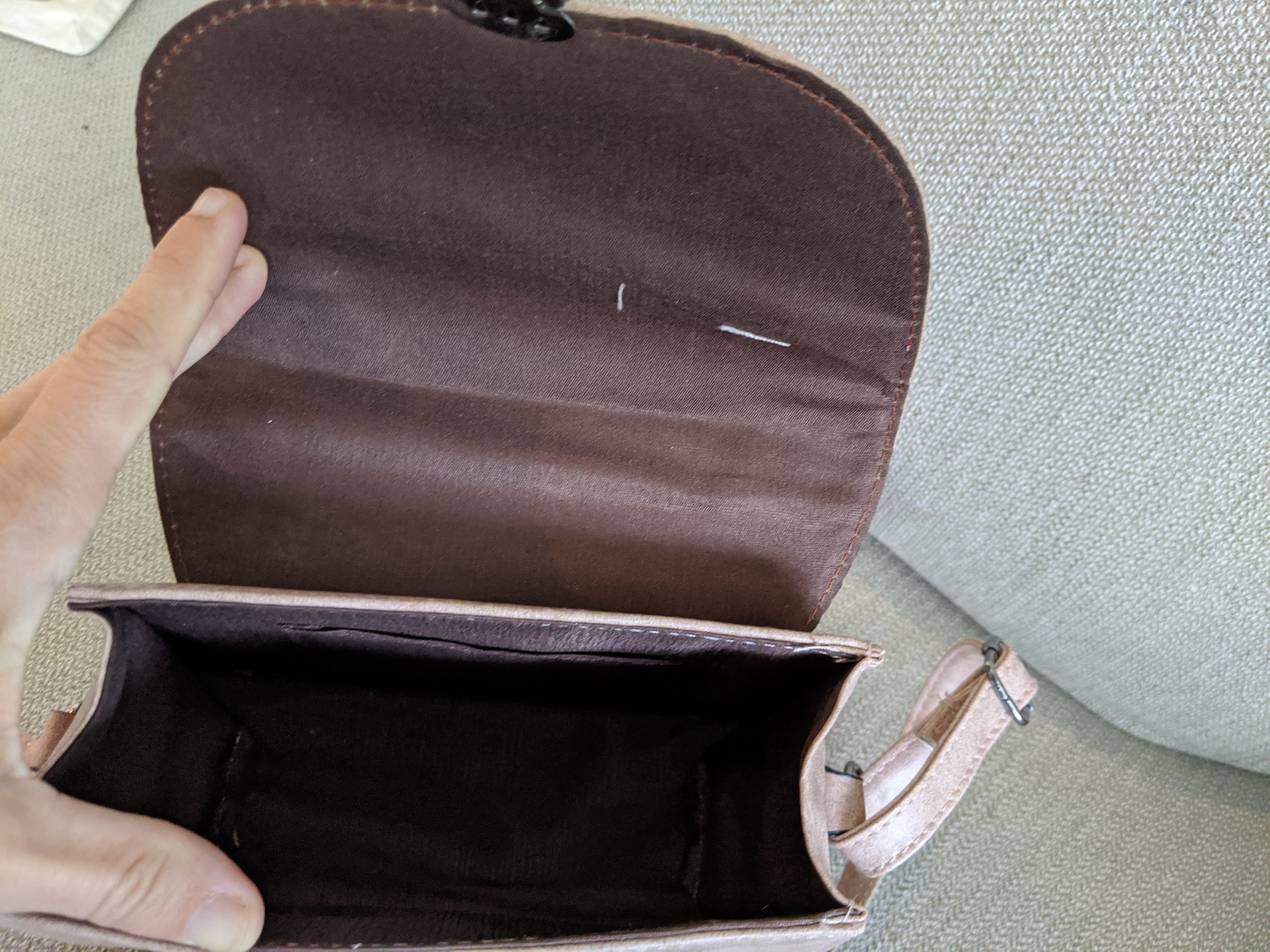 Light mauve faux leather marbled crossbody bag with adjustable strap, showcasing its soft texture and stylish design.