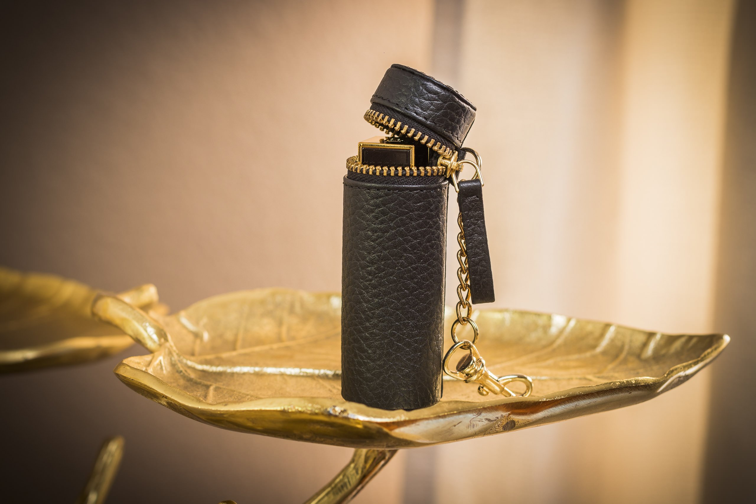 A stylish Lipstick Keeper made of genuine pebble leather, designed to hold lipsticks and chapsticks, featuring a compact size and attachment for bags.