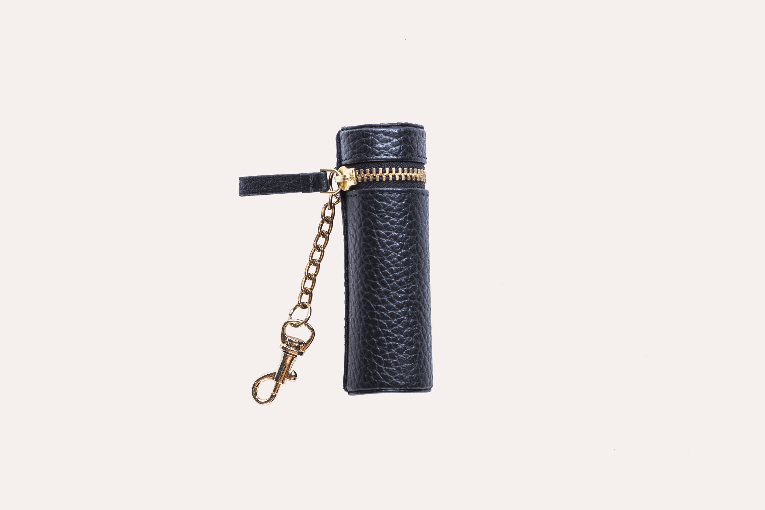 A stylish Lipstick Keeper made of genuine pebble leather, designed to hold lipsticks and chapsticks, featuring a compact size and attachment for bags.