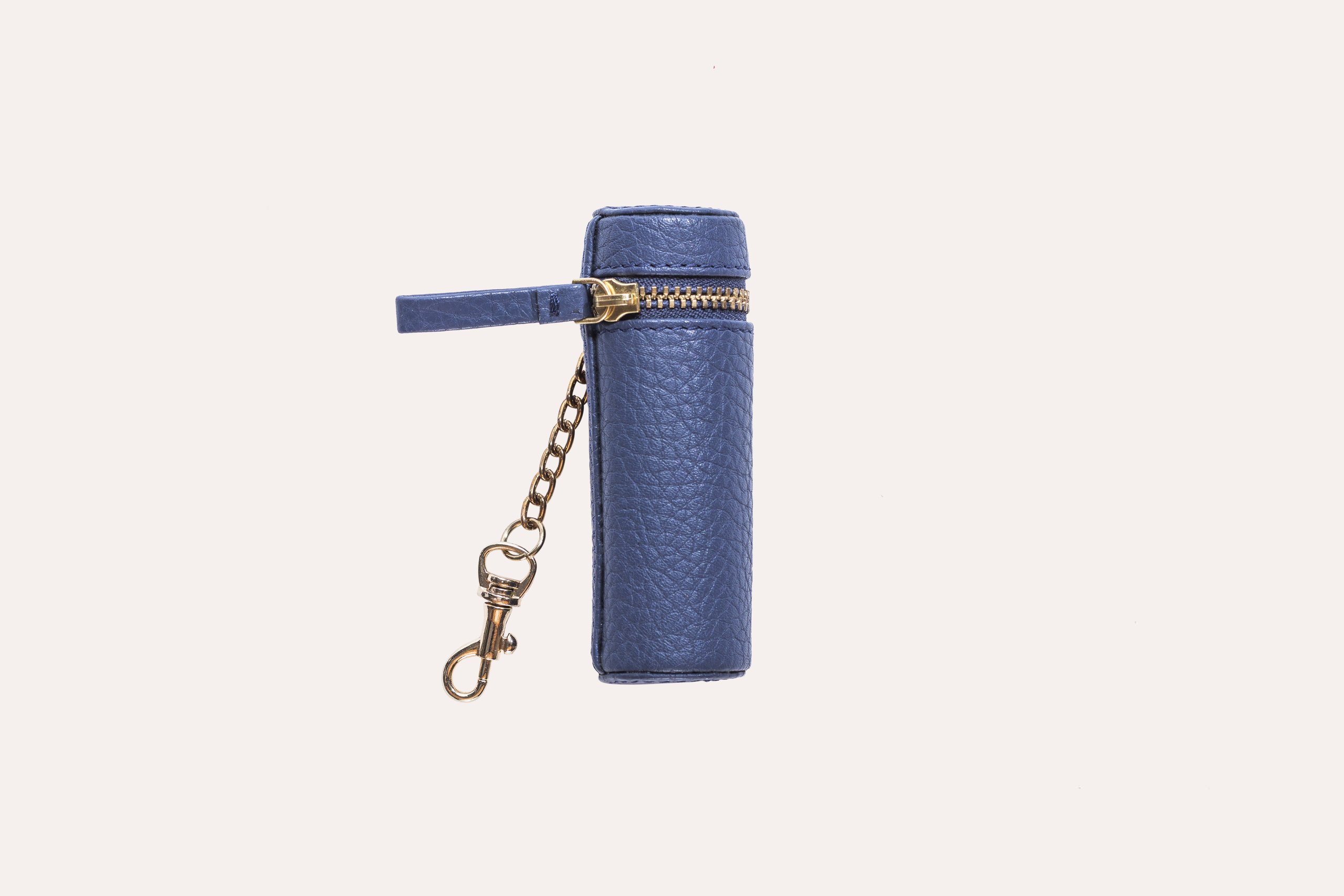 A stylish Lipstick Keeper made of genuine pebble leather, designed to hold lipsticks and chapsticks, featuring a compact size and attachment for bags.