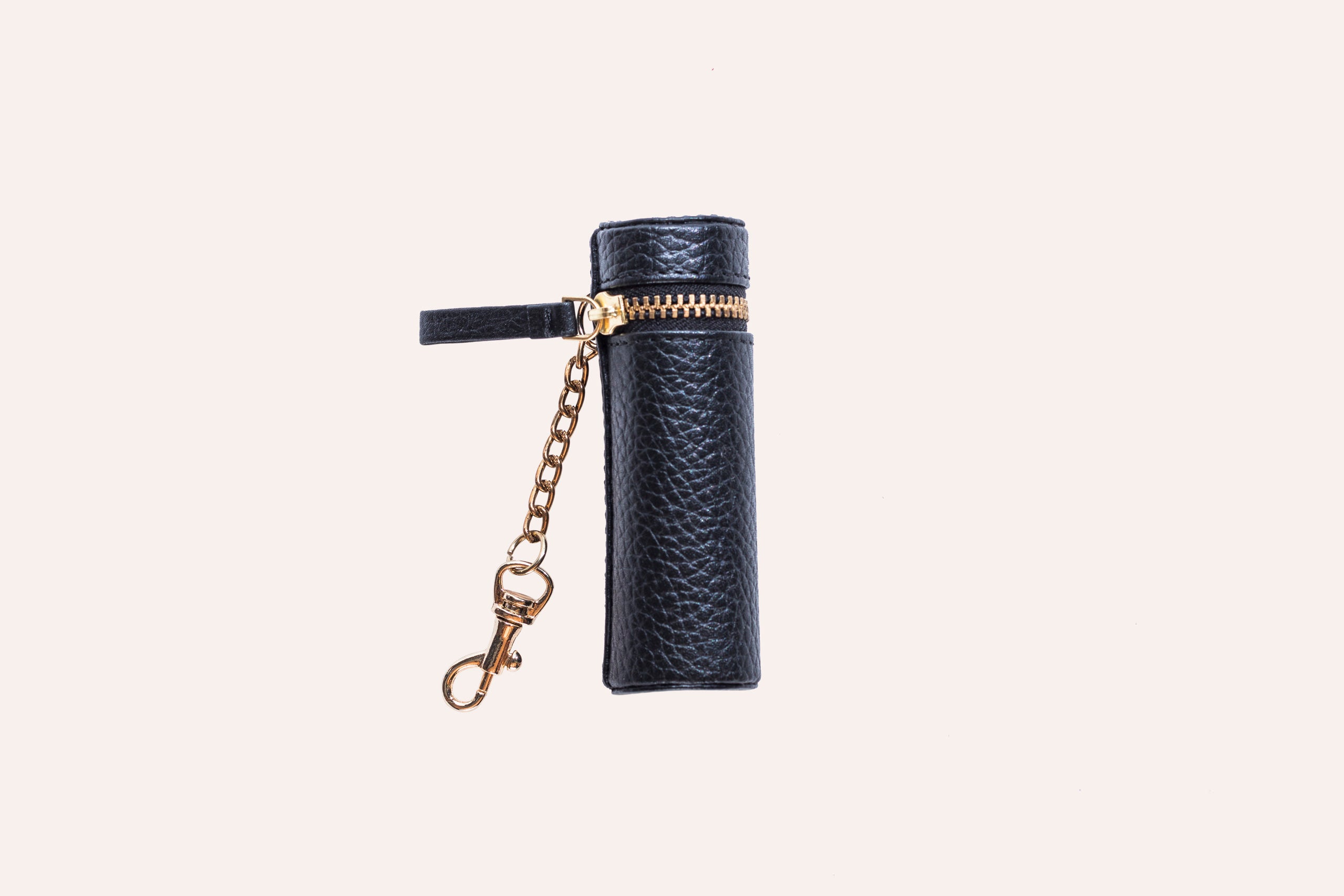 A stylish Lipstick Keeper made of genuine pebble leather, designed to hold lipsticks and chapsticks, featuring a compact size and attachment for bags.