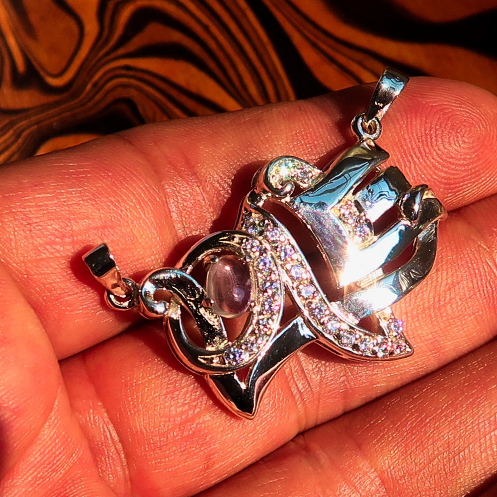 Sterling silver Love Pendant featuring a moonstone centerpiece and cubic zirconia accents, elegantly designed with the word 'LOVE'.