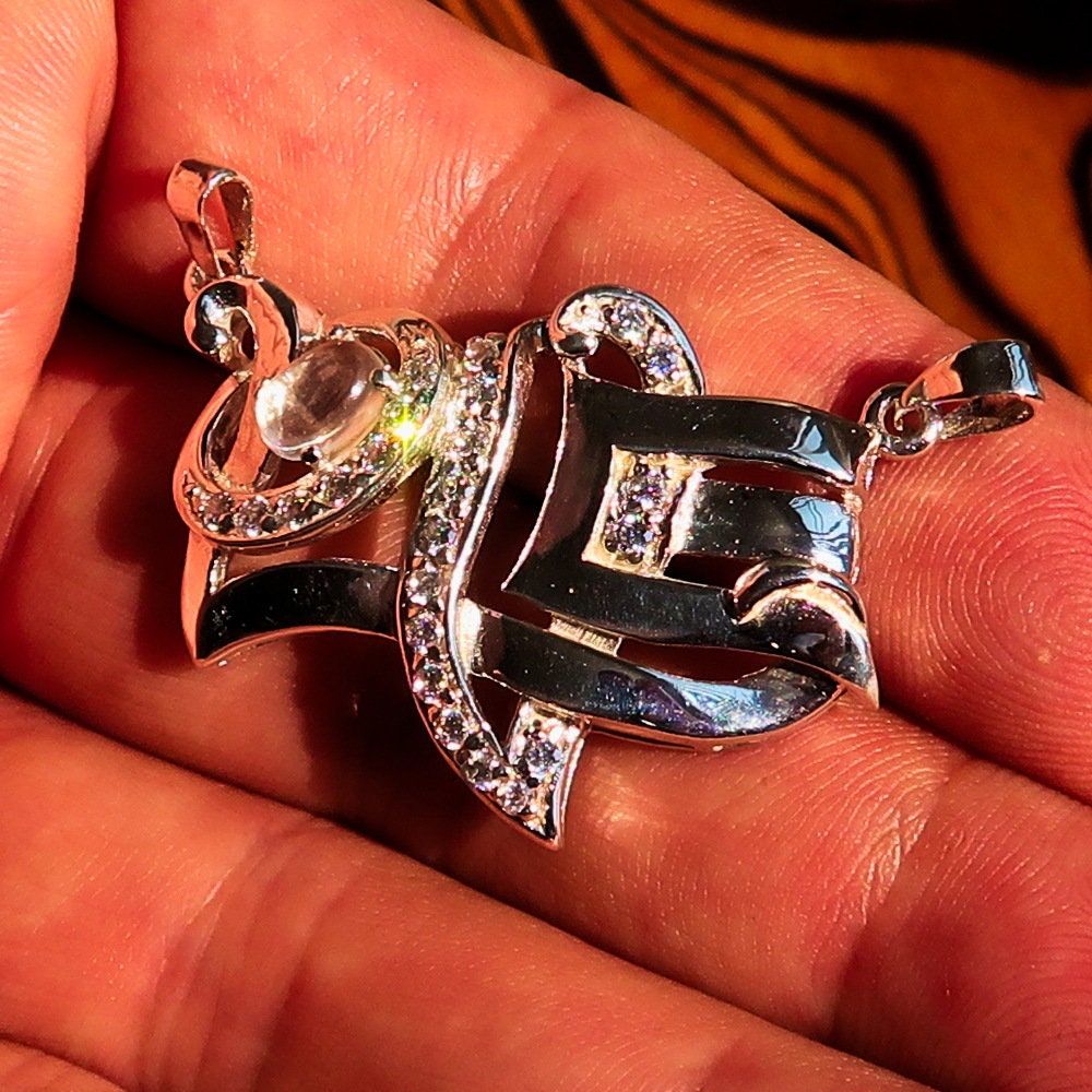 Sterling silver Love Pendant featuring a moonstone centerpiece and cubic zirconia accents, elegantly designed with the word 'LOVE'.