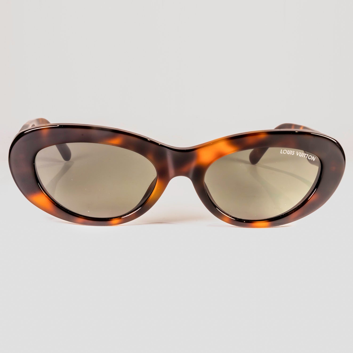 A pair of LV Fame Oval Sunglasses featuring chunky black acetate frames and full black lenses, adorned with LV initials and Monogram Flower details.