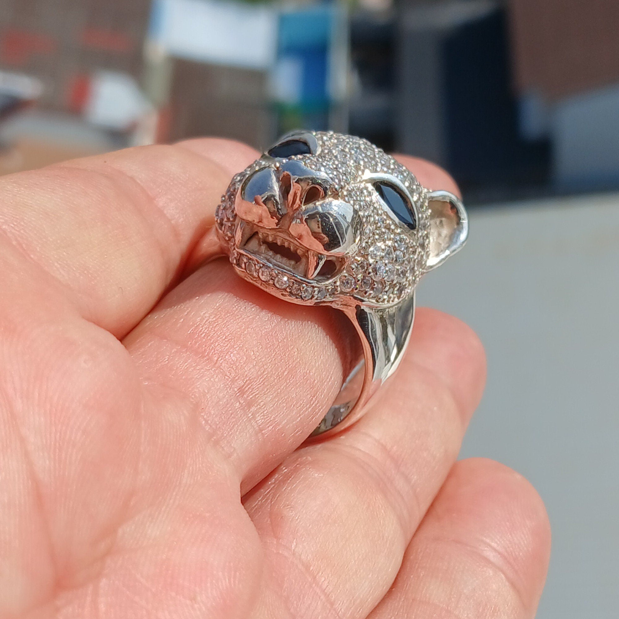 Men's Panther Ring in sterling silver with cubic zirconia stones and blue sapphire CZ eyes, showcasing intricate handcrafted design.