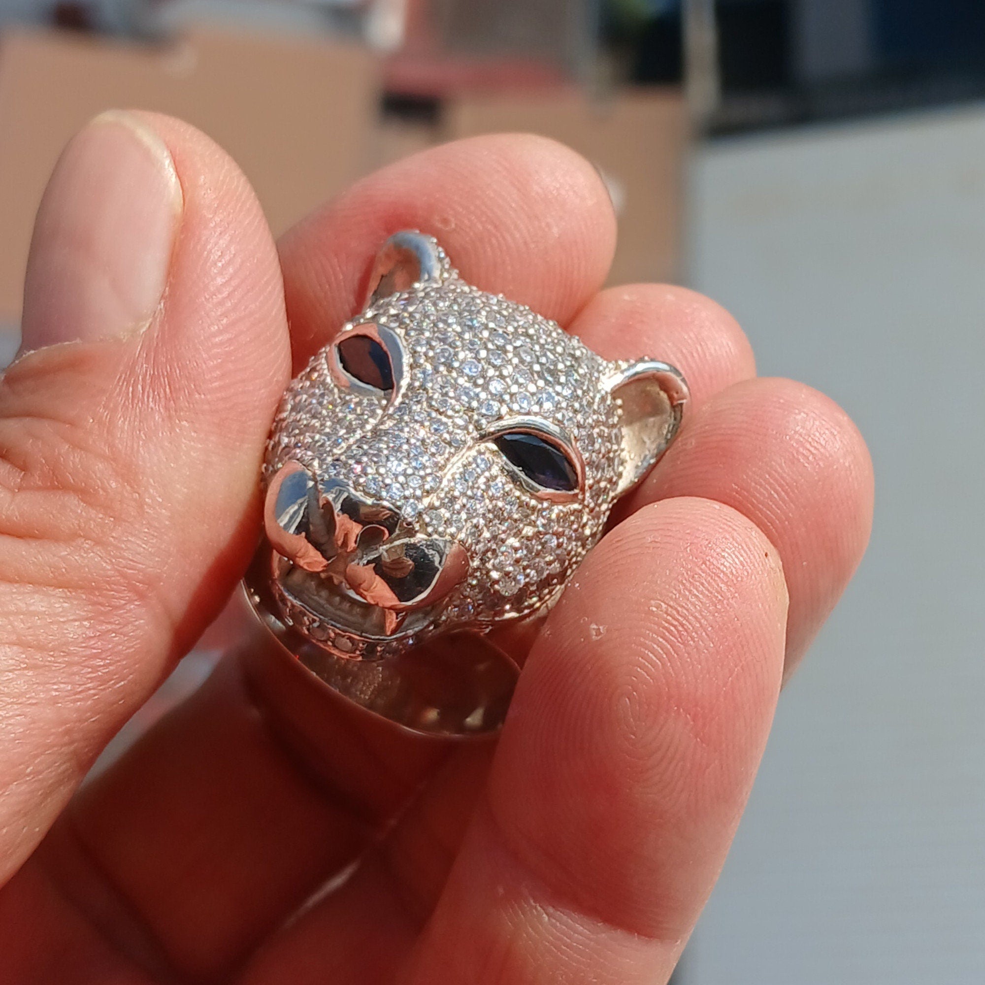 Men's Panther Ring in sterling silver with cubic zirconia stones and blue sapphire CZ eyes, showcasing intricate handcrafted design.