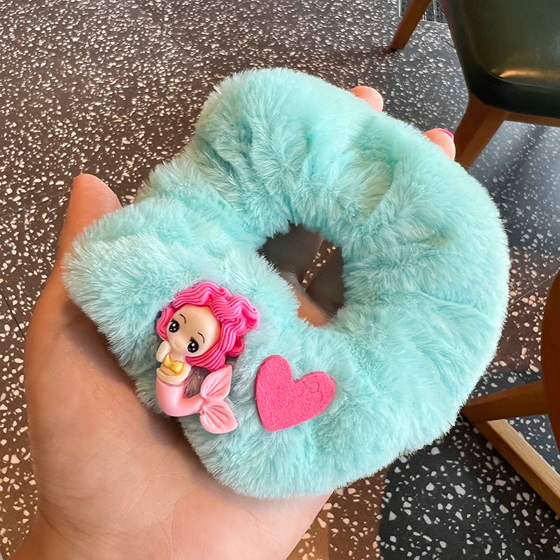 A vibrant Mermaid Blue Hair Tie featuring a woman holding blue hair ties with cute mermaid designs, perfect for whimsical hairstyles.