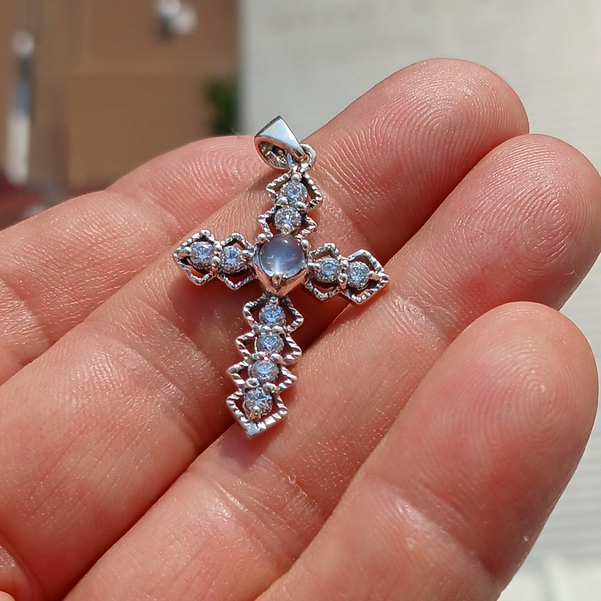 Moonstone Crucifix Sterling Silver Pendant featuring a round Ceylon Moonstone and sparkling CZ stones, elegantly designed.