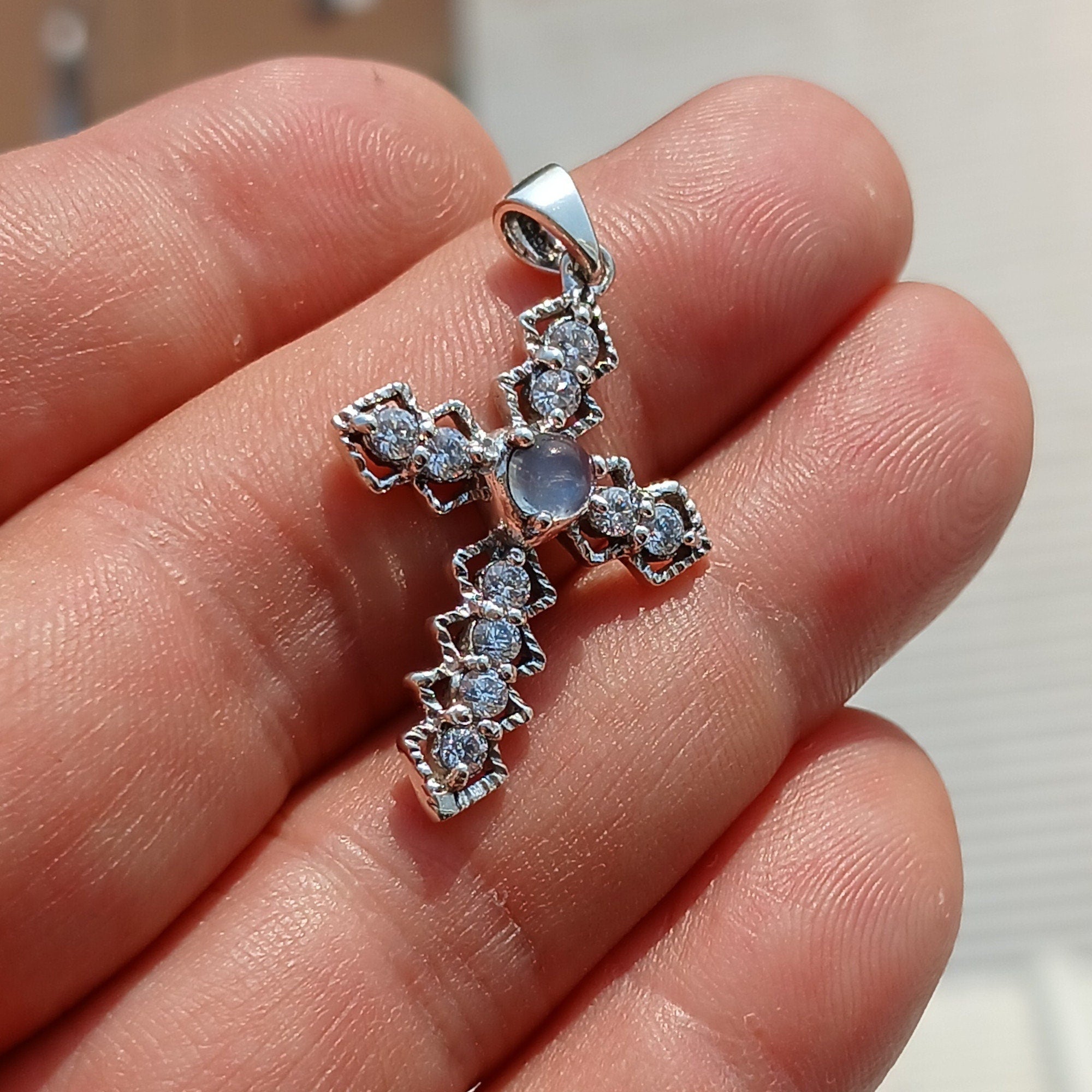 Moonstone Crucifix Sterling Silver Pendant featuring a round Ceylon Moonstone and sparkling CZ stones, elegantly designed.