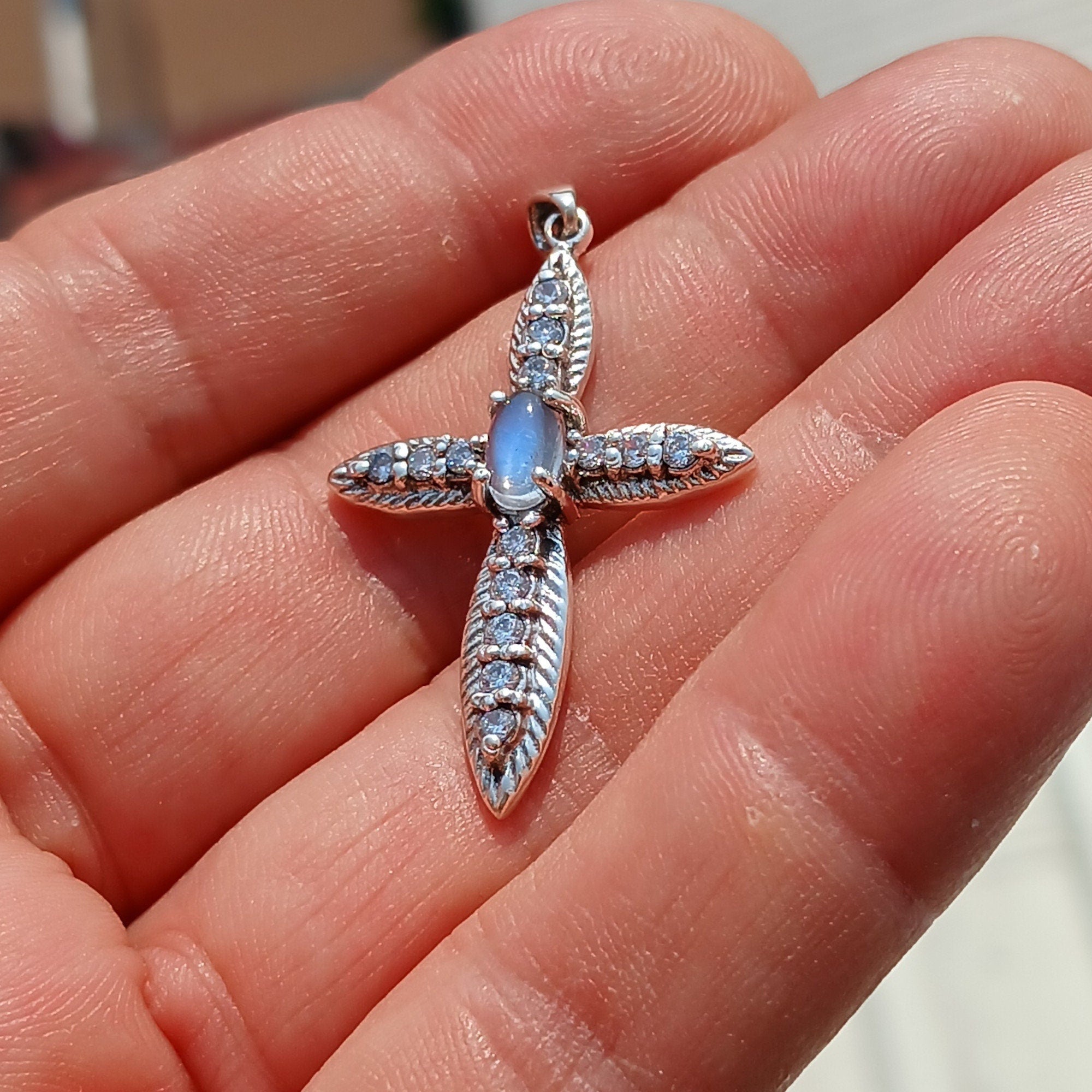 Moonstone Crucifix Sterling Silver Pendant featuring an oval Ceylon Moonstone and 14 sparkling CZ stones, elegantly designed.