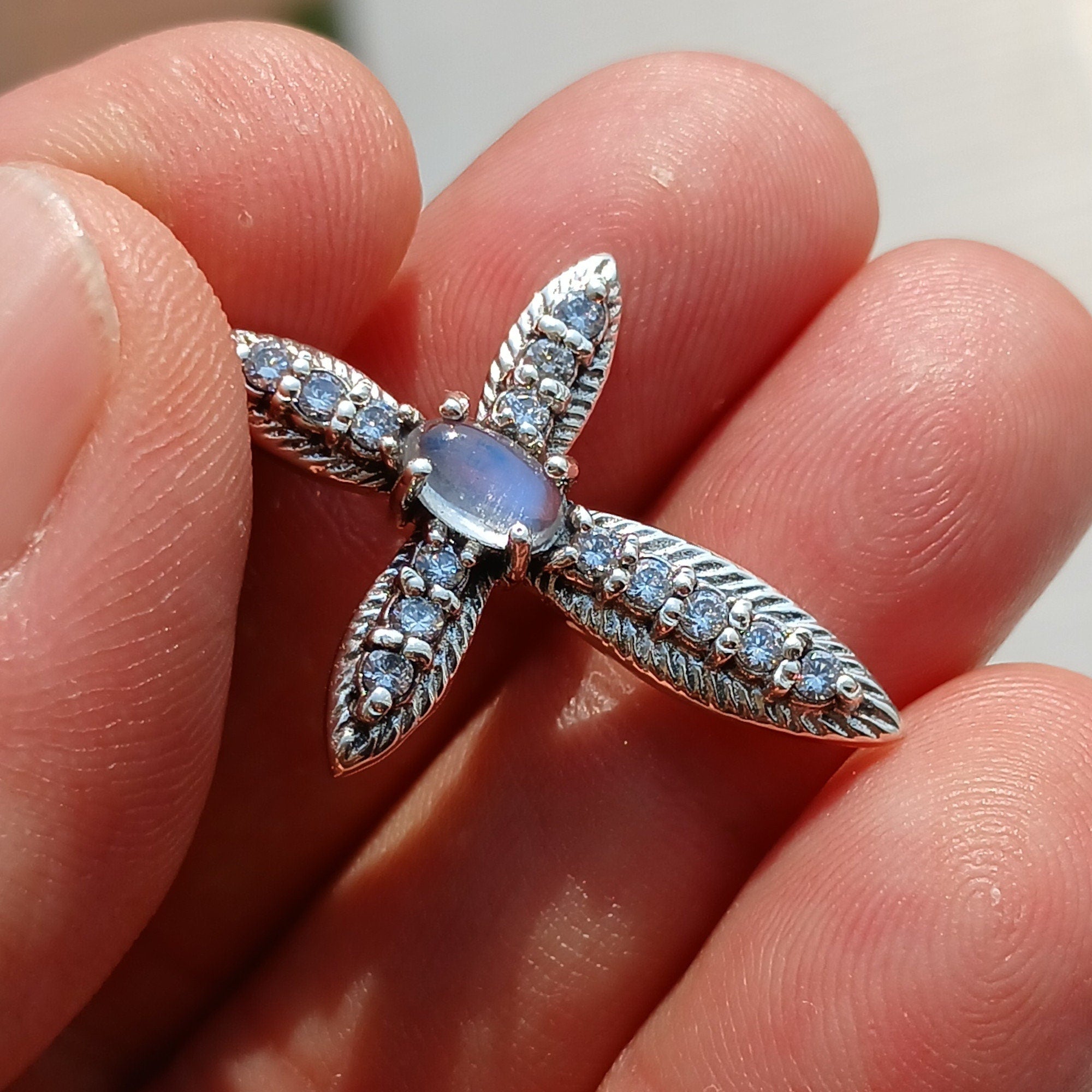 Moonstone Crucifix Sterling Silver Pendant featuring an oval Ceylon Moonstone and 14 sparkling CZ stones, elegantly designed.