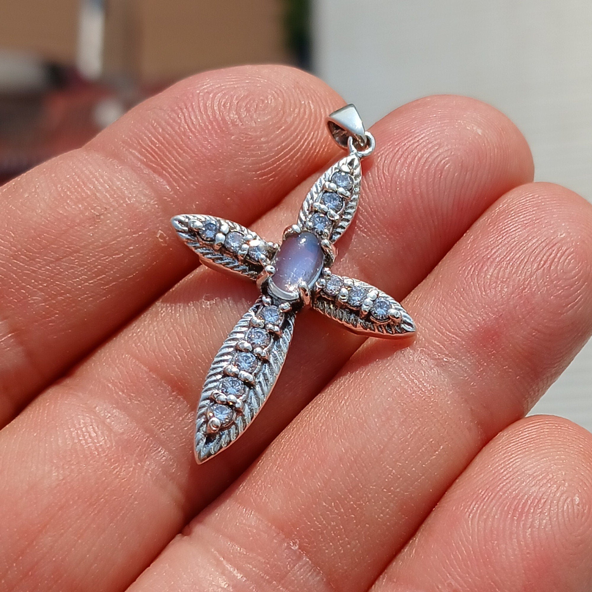 Moonstone Crucifix Sterling Silver Pendant featuring an oval Ceylon Moonstone and 14 sparkling CZ stones, elegantly designed.