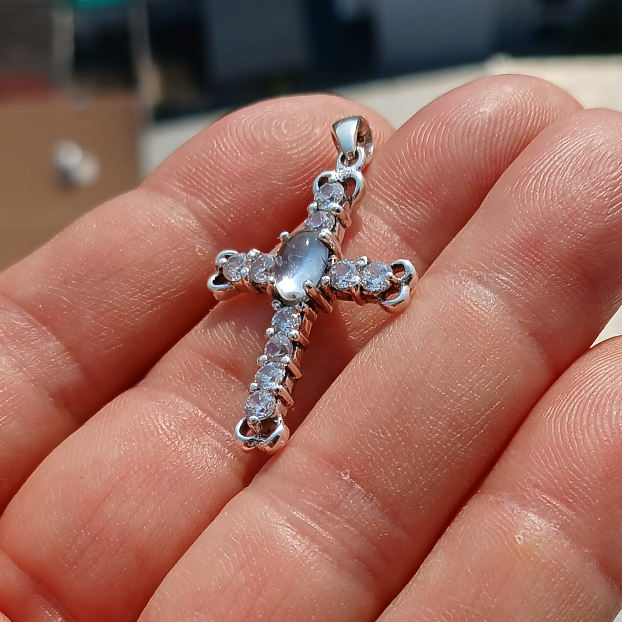 Moonstone Crucifix Sterling Silver Pendant featuring an oval Ceylon Moonstone and cubic zirconia stones, elegantly designed as a cross amulet.