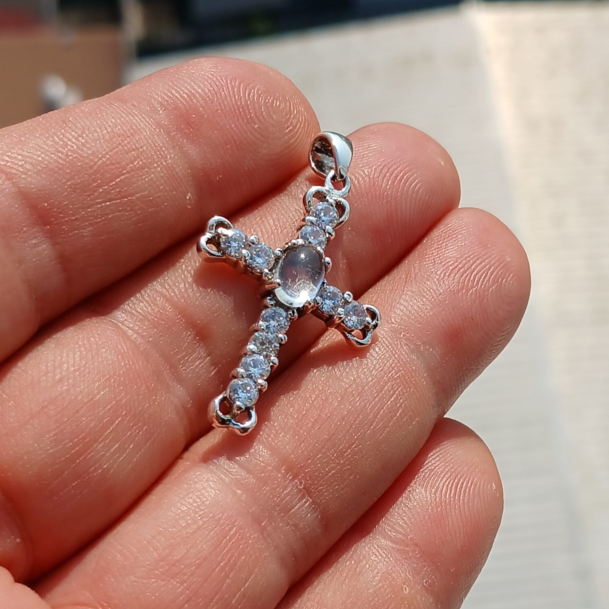 Moonstone Crucifix Sterling Silver Pendant featuring an oval Ceylon Moonstone and cubic zirconia stones, elegantly designed as a cross amulet.