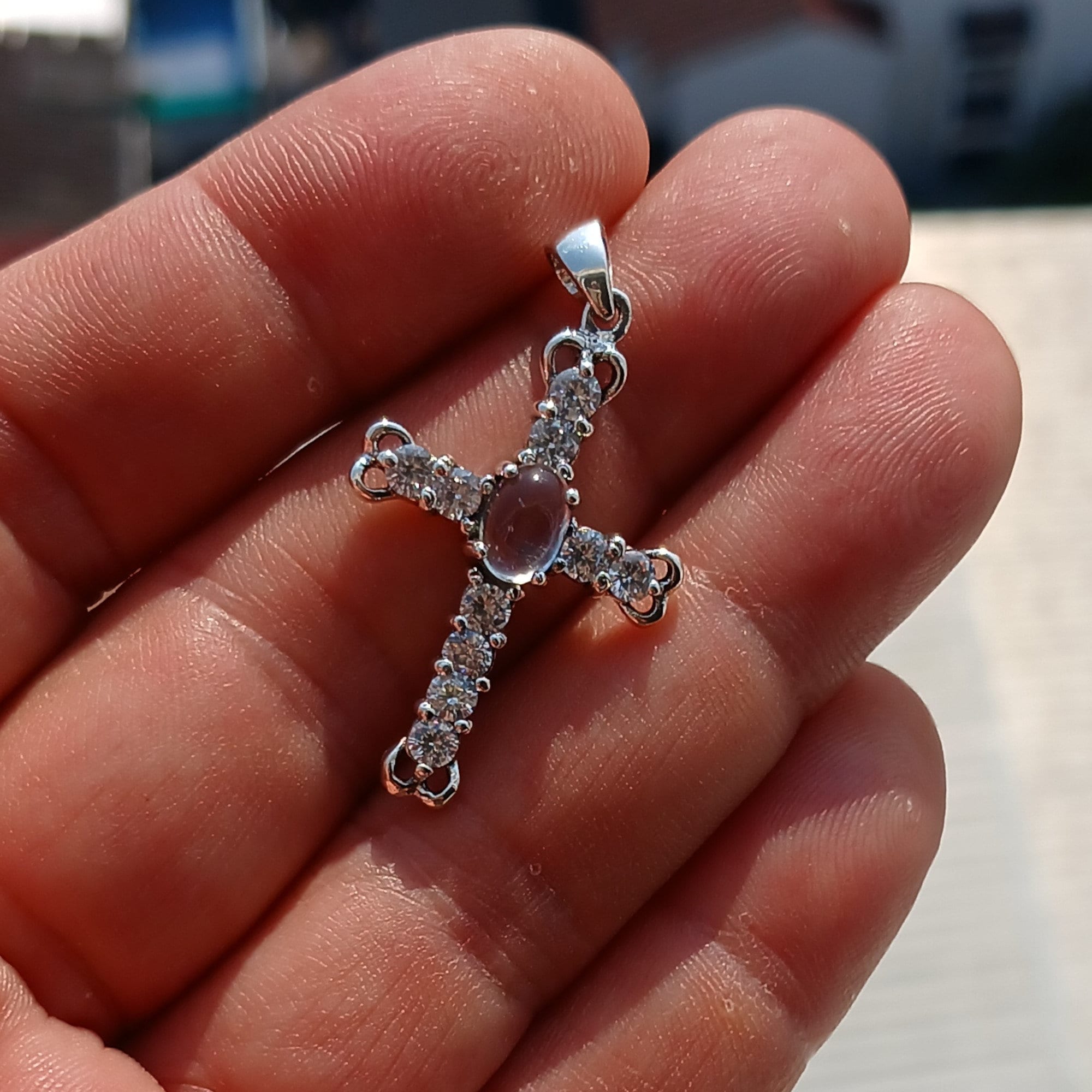 Moonstone Crucifix Sterling Silver Pendant featuring an oval Ceylon Moonstone and cubic zirconia stones, elegantly designed as a cross amulet.