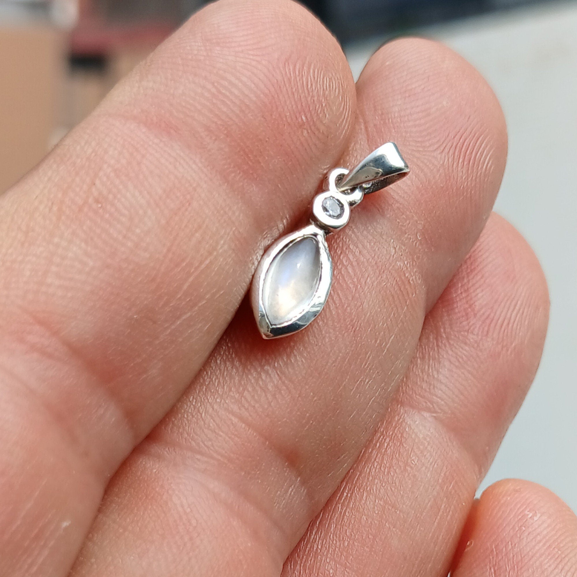 A stunning sterling silver Moonstone Pendant featuring a Ceylon Moonstone and CZ, showcasing its iridescent beauty.