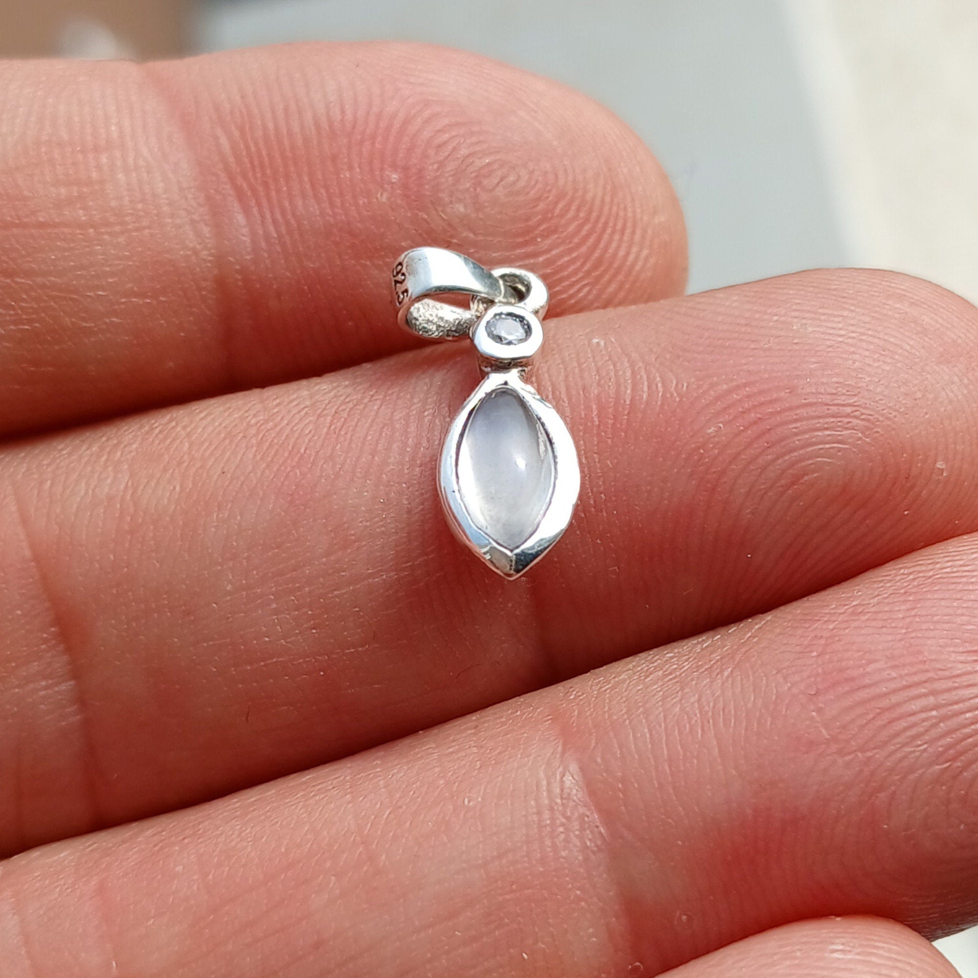 A stunning sterling silver Moonstone Pendant featuring a Ceylon Moonstone and CZ, showcasing its iridescent beauty.