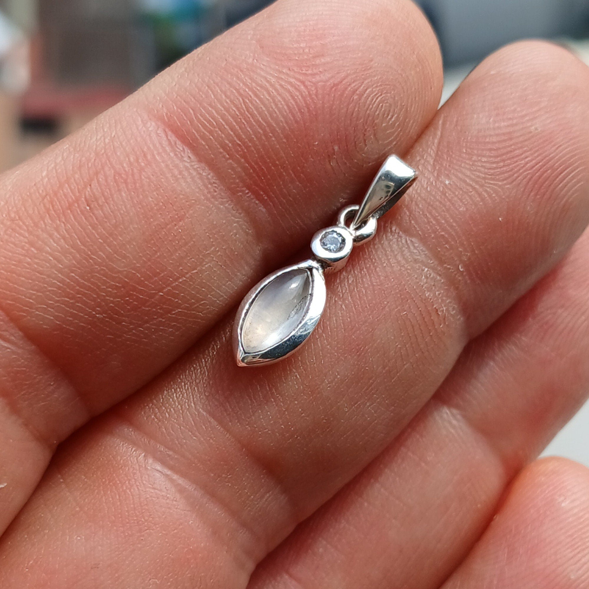 A stunning sterling silver Moonstone Pendant featuring a Ceylon Moonstone and CZ, showcasing its iridescent beauty.