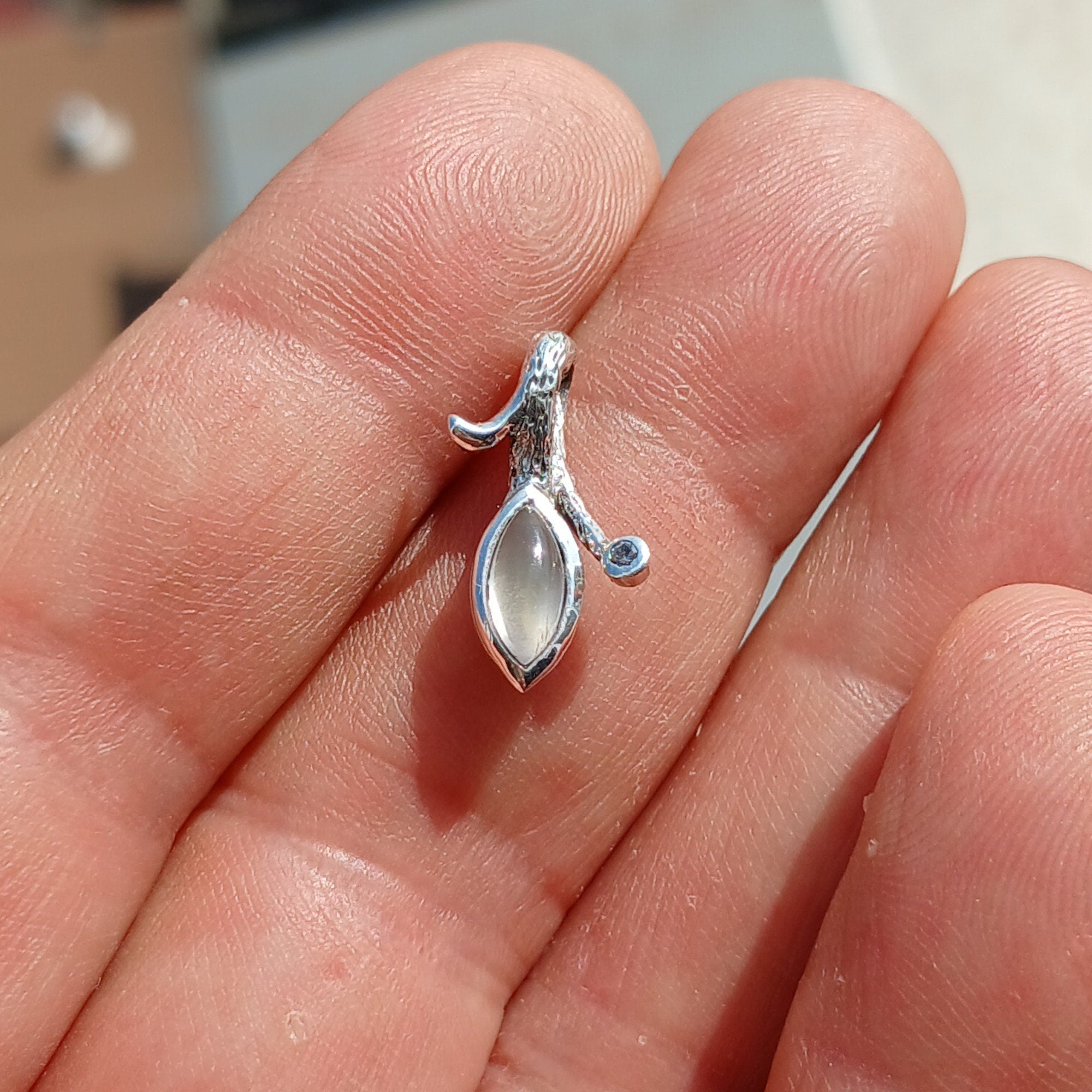 A beautiful sterling silver pendant featuring a marquise Ceylon Moonstone, accented with sparkling Cubic Zirconias, showcasing its elegant design.