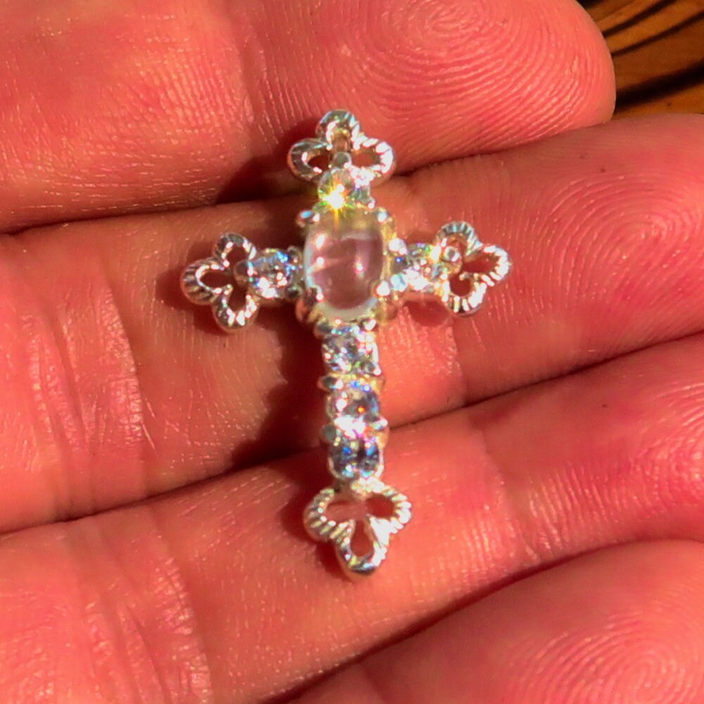 Sterling silver cross pendant featuring a moonstone and cubic zirconia, showcasing intricate design and craftsmanship.