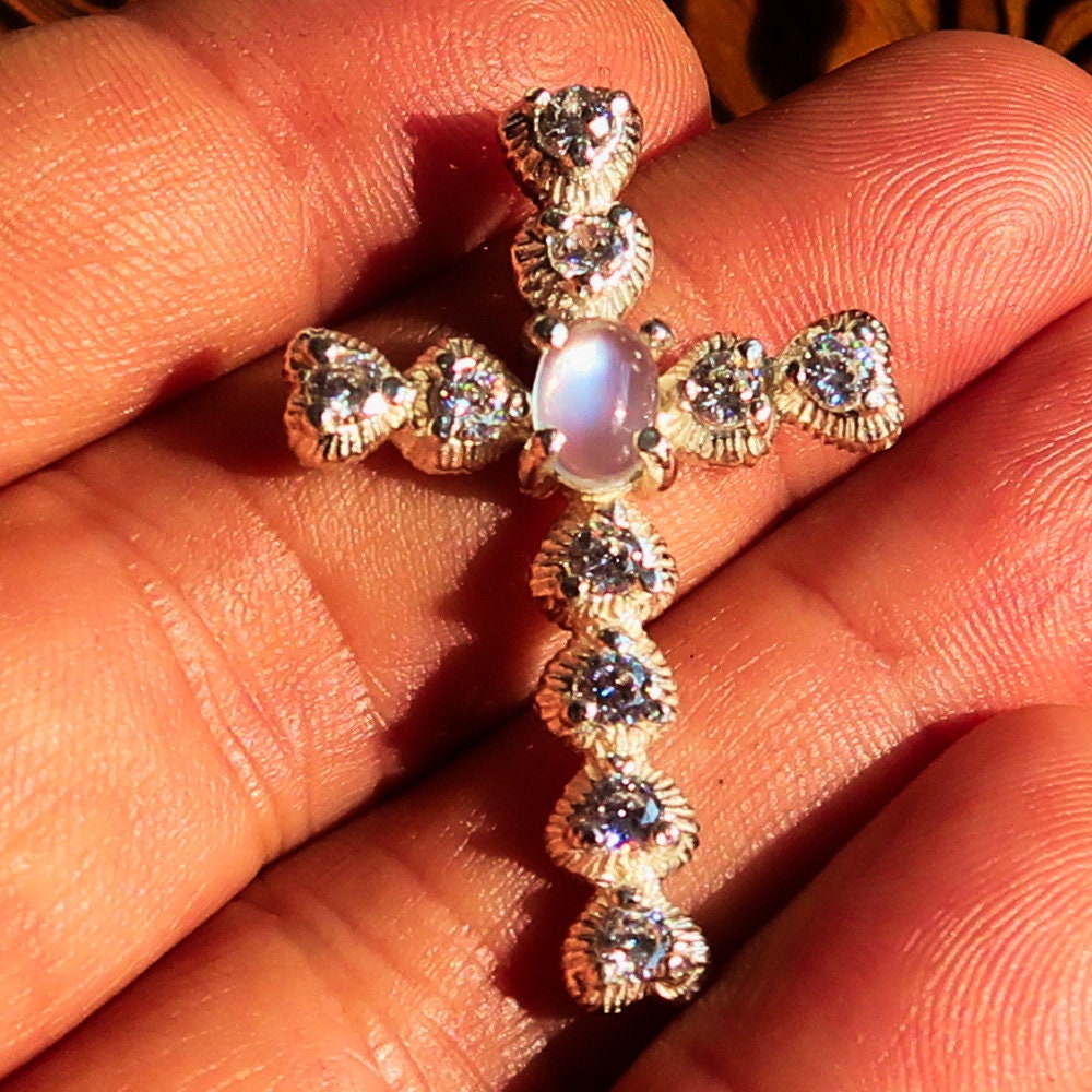 Elegant oval-shaped Moonstone Pendant in sterling silver with cubic zirconias, featuring a cross design.