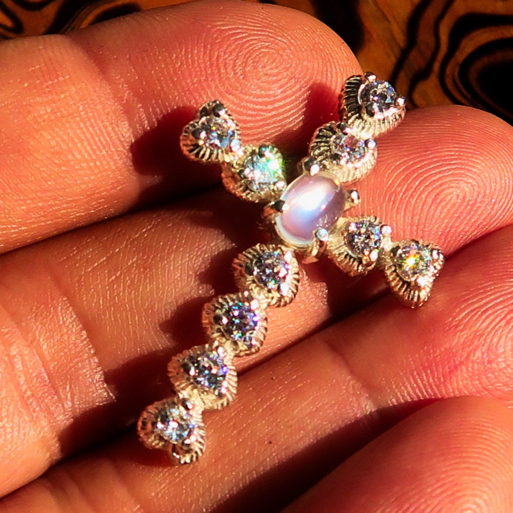 Elegant oval-shaped Moonstone Pendant in sterling silver with cubic zirconias, featuring a cross design.