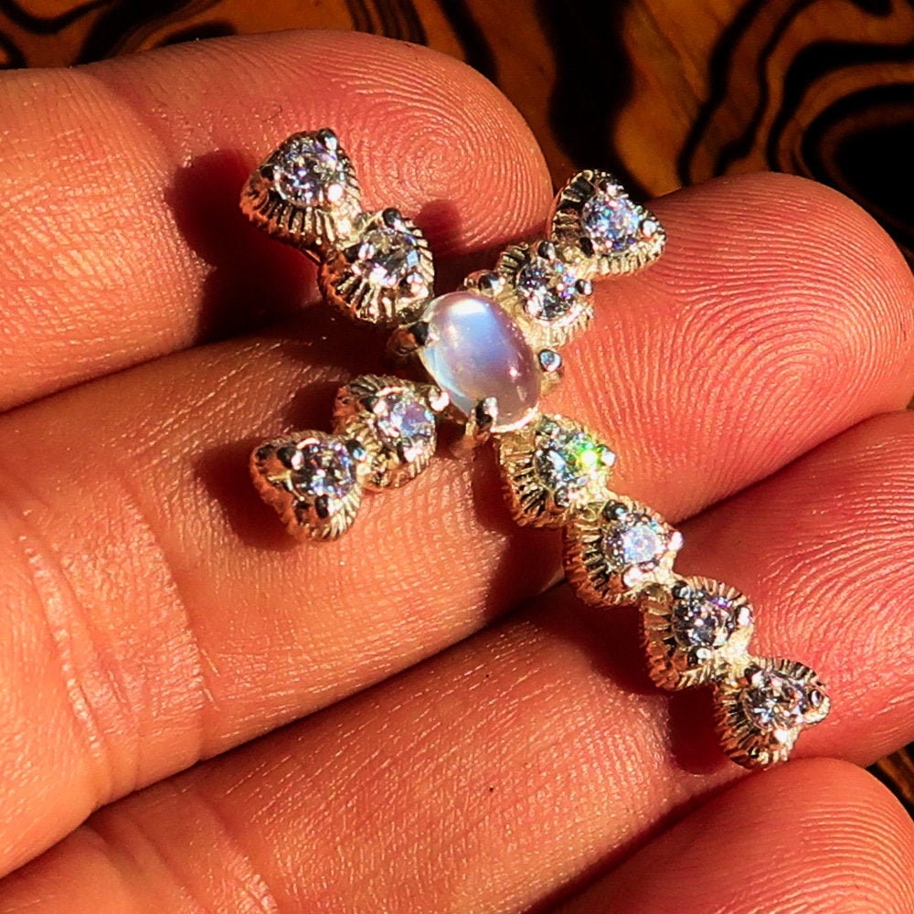 Elegant oval-shaped Moonstone Pendant in sterling silver with cubic zirconias, featuring a cross design.