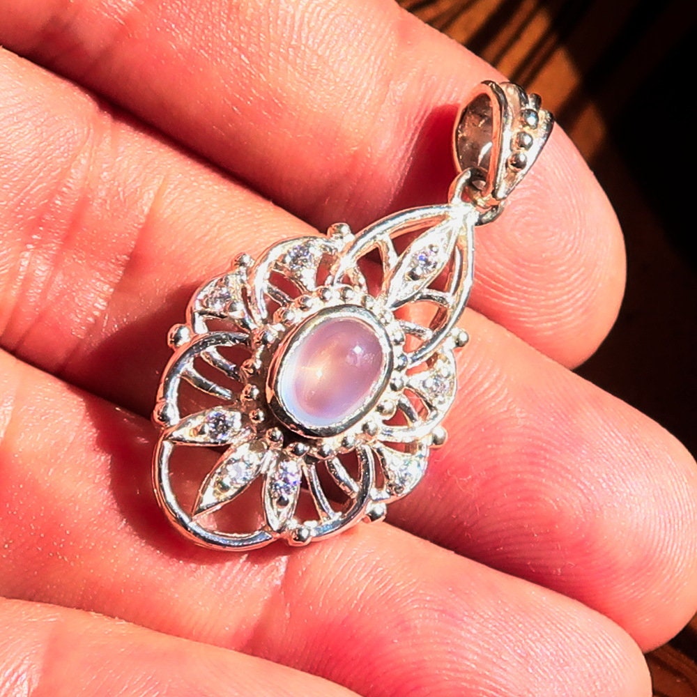 A stunning handmade Moonstone Pendant featuring an oval Ceylon moonstone set in a sterling silver frame, adorned with cubic zirconias.