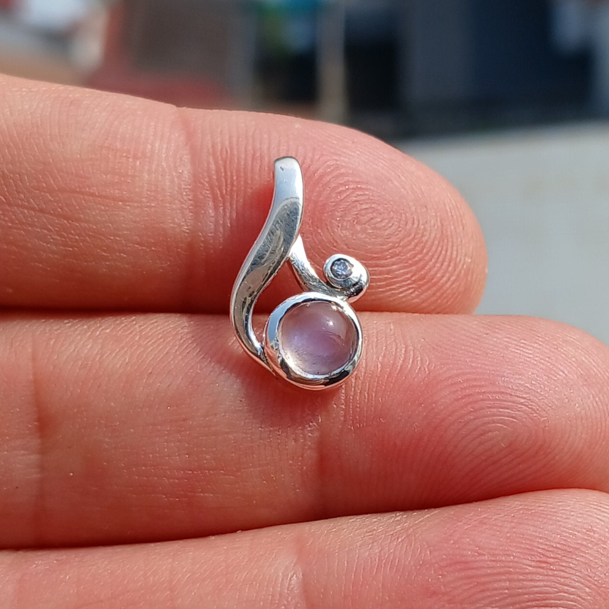 A beautiful sterling silver moonstone pendant featuring cubic zirconias, showcasing its elegant design and dimensions.