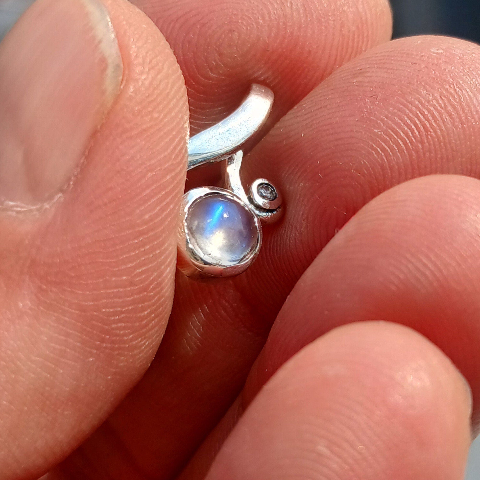 A beautiful sterling silver moonstone pendant featuring cubic zirconias, showcasing its elegant design and dimensions.